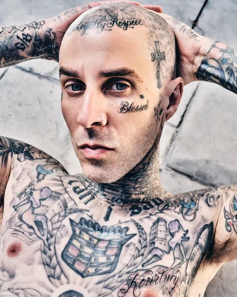 A photo showing Travis Barker showing off his tattoos