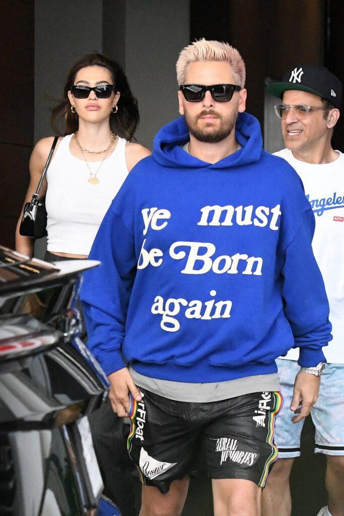 Scott Disick wears an interesting slogan sweatshirt while girlfriend Amelia Hamlin dresses up in heels as they are seen leaving their hotel in Miami