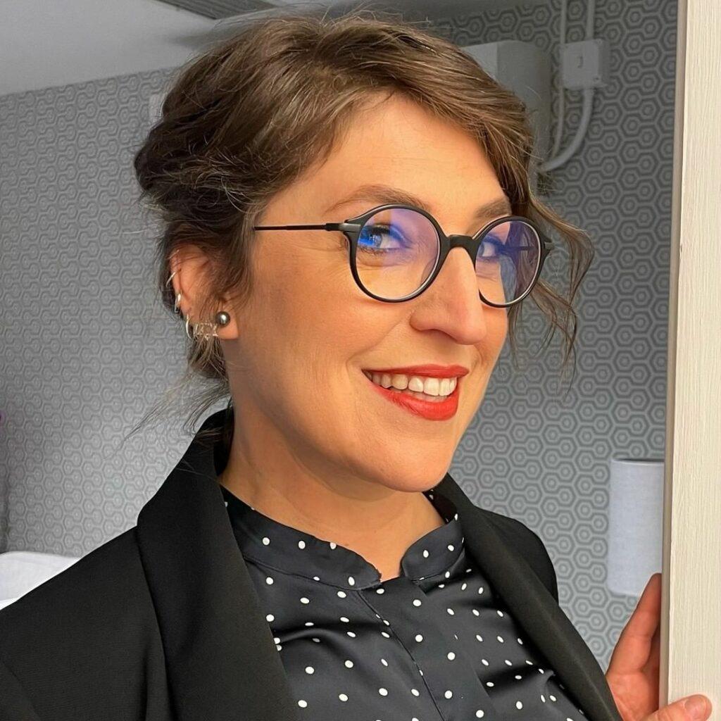 A selfie showing Mayim Bialik sporting a black suit over a polka dot design blouse
