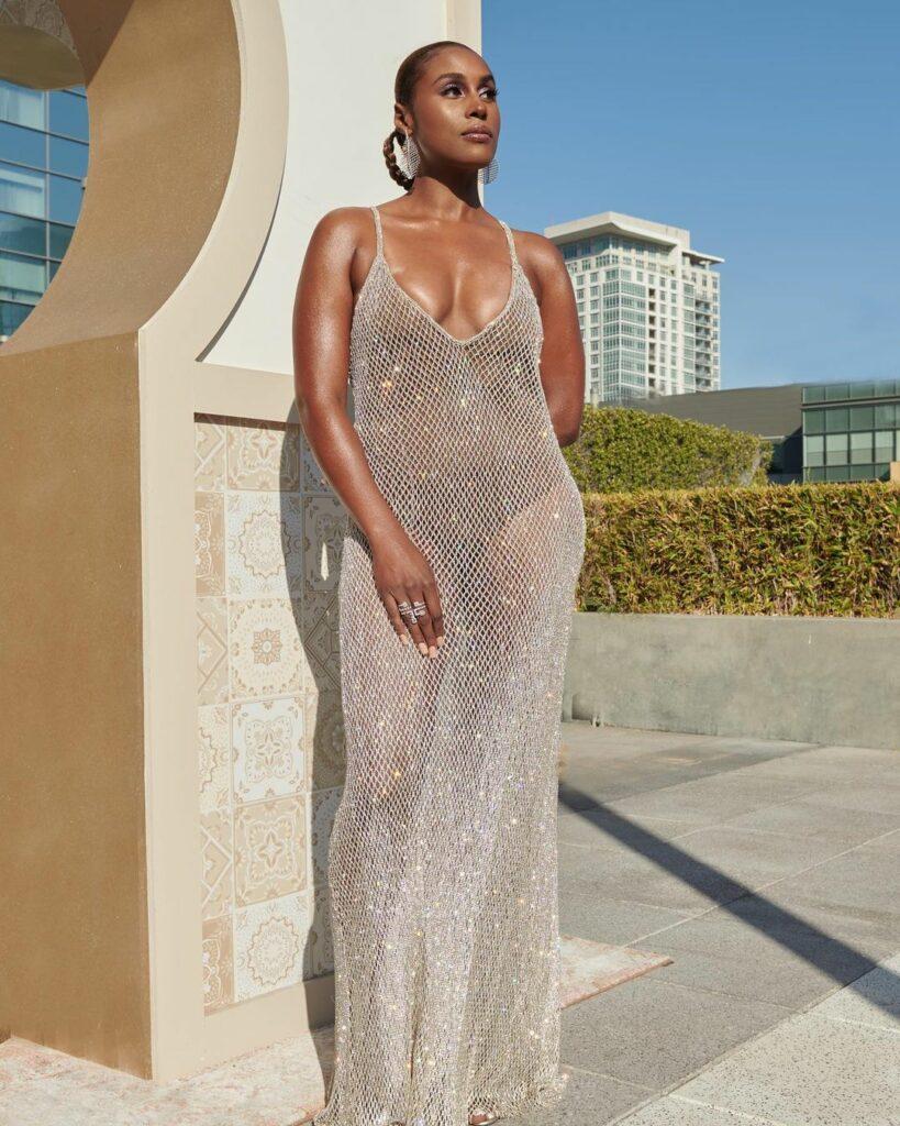 A photo showing Issa Rae in a shiny see-through outfit, and she looks glamorous.