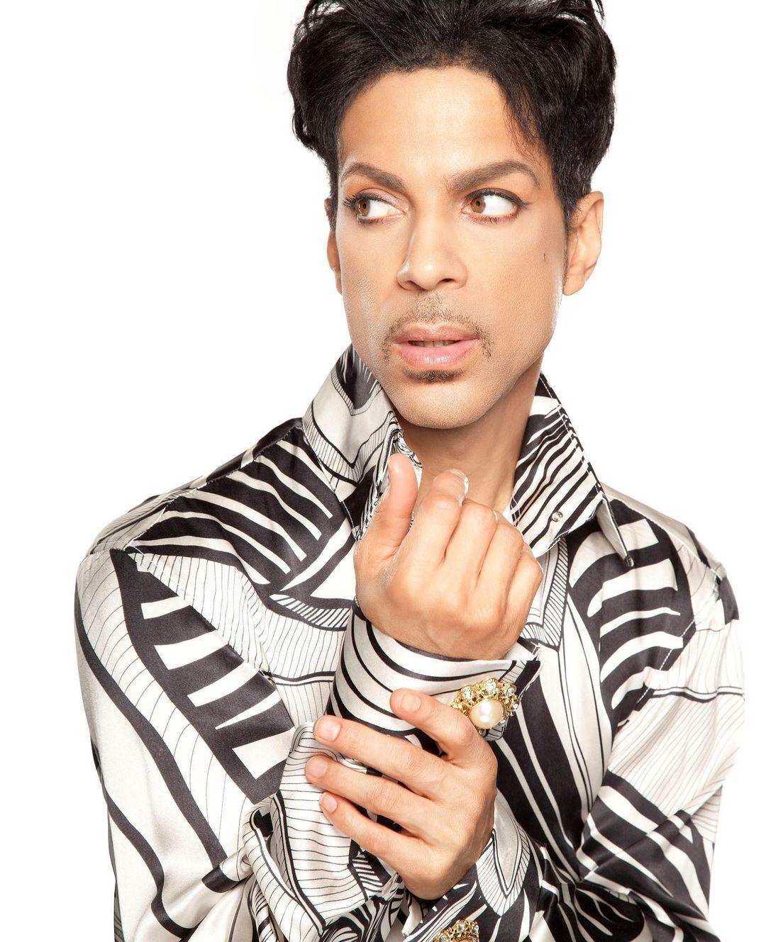 A photo showing Prince in a striped outfit, with gorgeous hair.