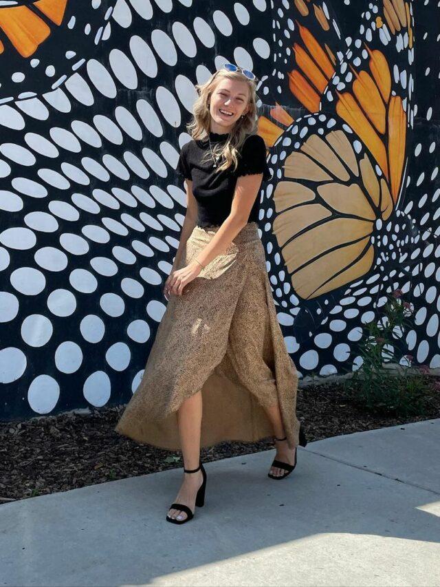 Gabby walking in front of butterfly wall