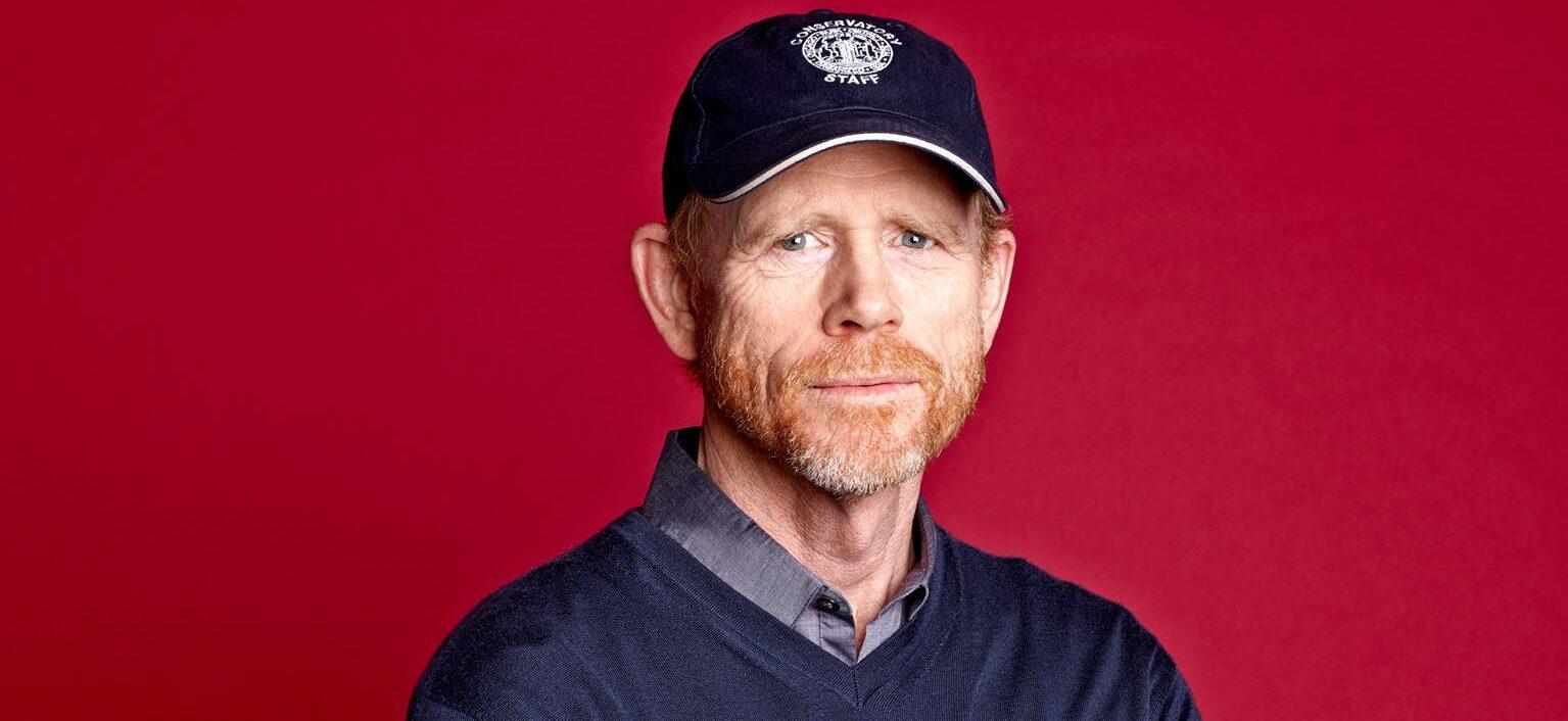 A photo showing Ron Howard sporting a blue sweater over a gray T-shirt and a sports cap to match