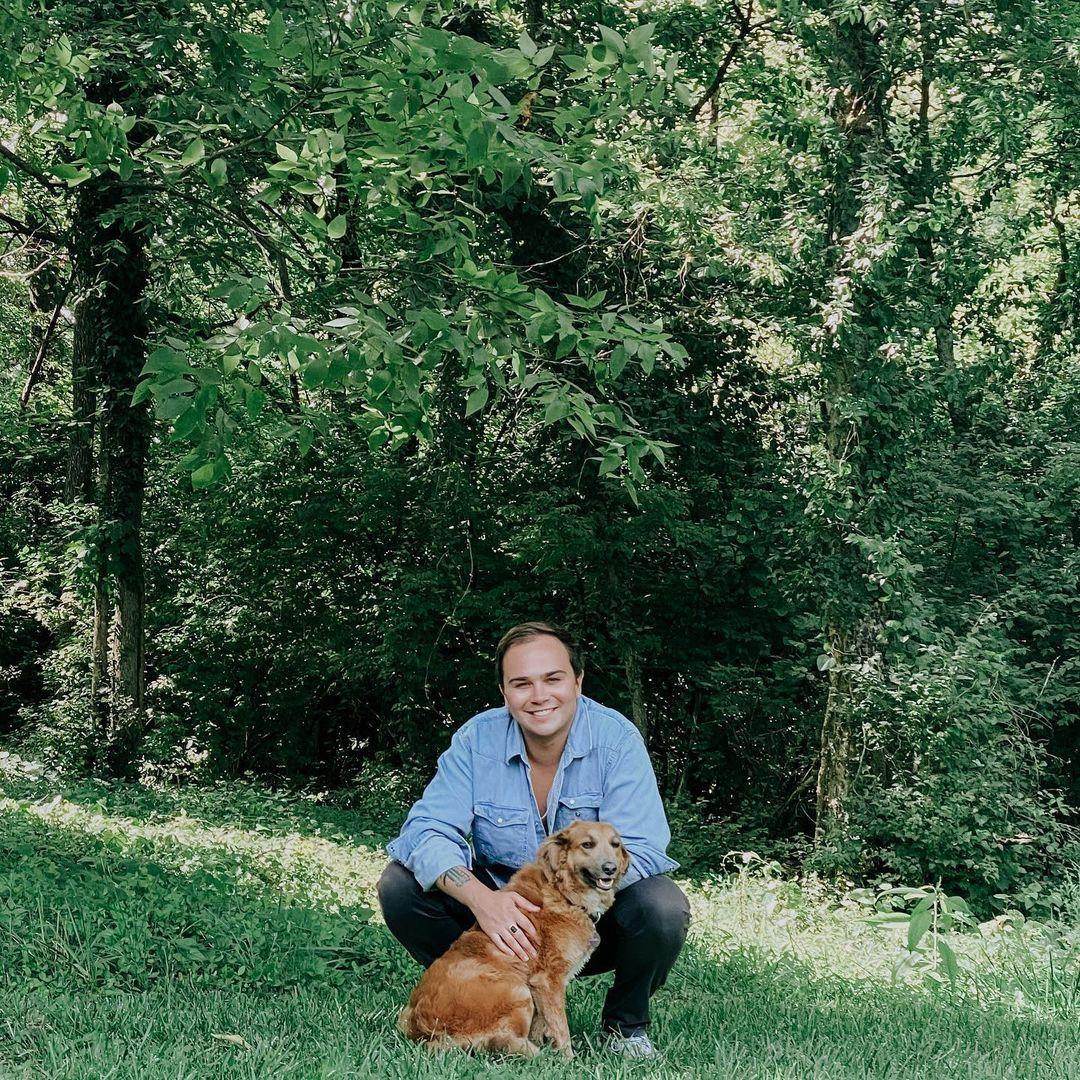 A photo showing Tommy Prine playing in the field with his dog.
