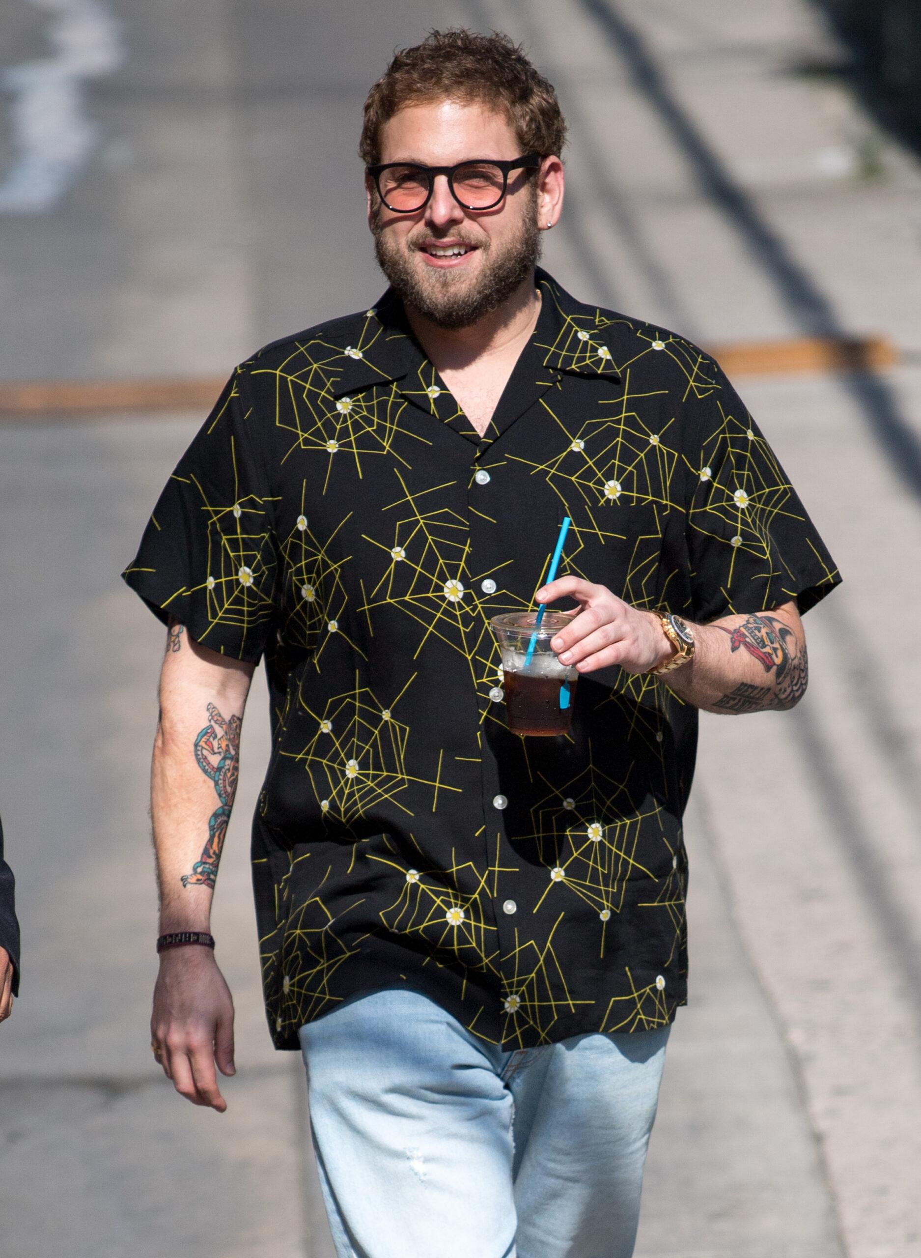 Jonah Hill at 'Jimmy Kimmel Live' in a black T-shirt with yellow designs and a blue pant.