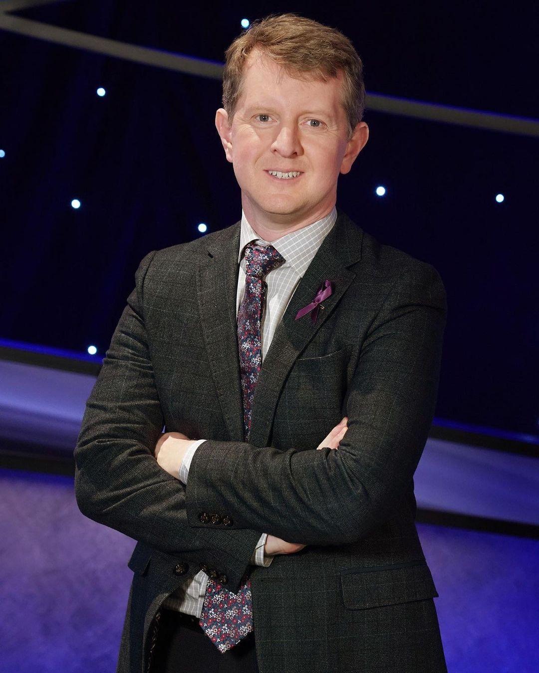 A photo showing Ken Jennings in a black suit and striped tie.