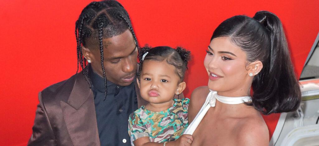 Travis Scott, Stormi Webster, and Kylie Jenner posing for the camera.