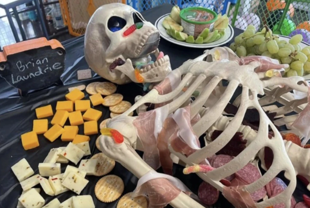 fake skeleton with deli meat and gummy worms on it 