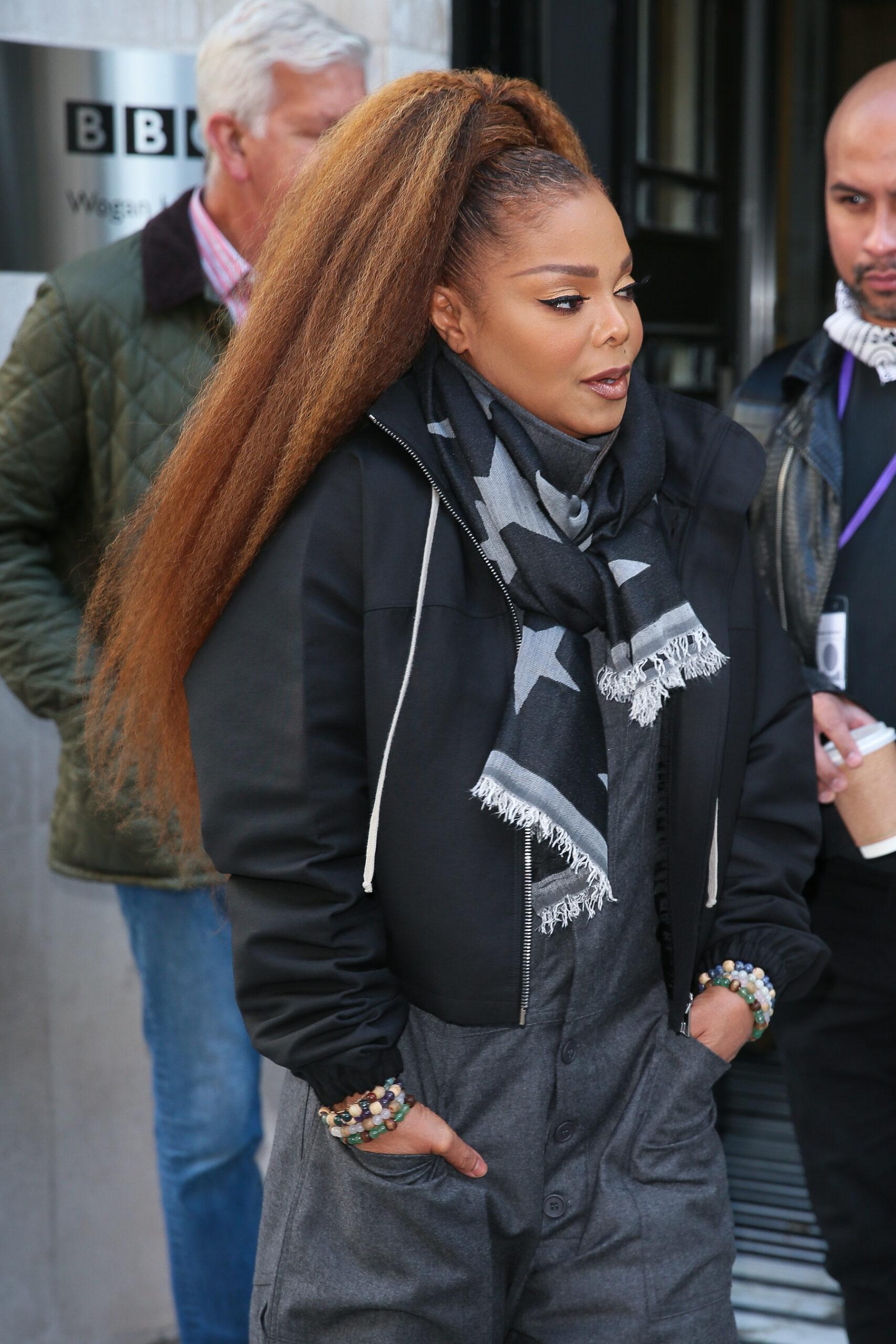 Singer Janet Jackson shows off her short slicked back hair and wears a  trendy asymmetrical jacket with a belt and leather pants at a book signing  promoting her book TRUE YOU: A