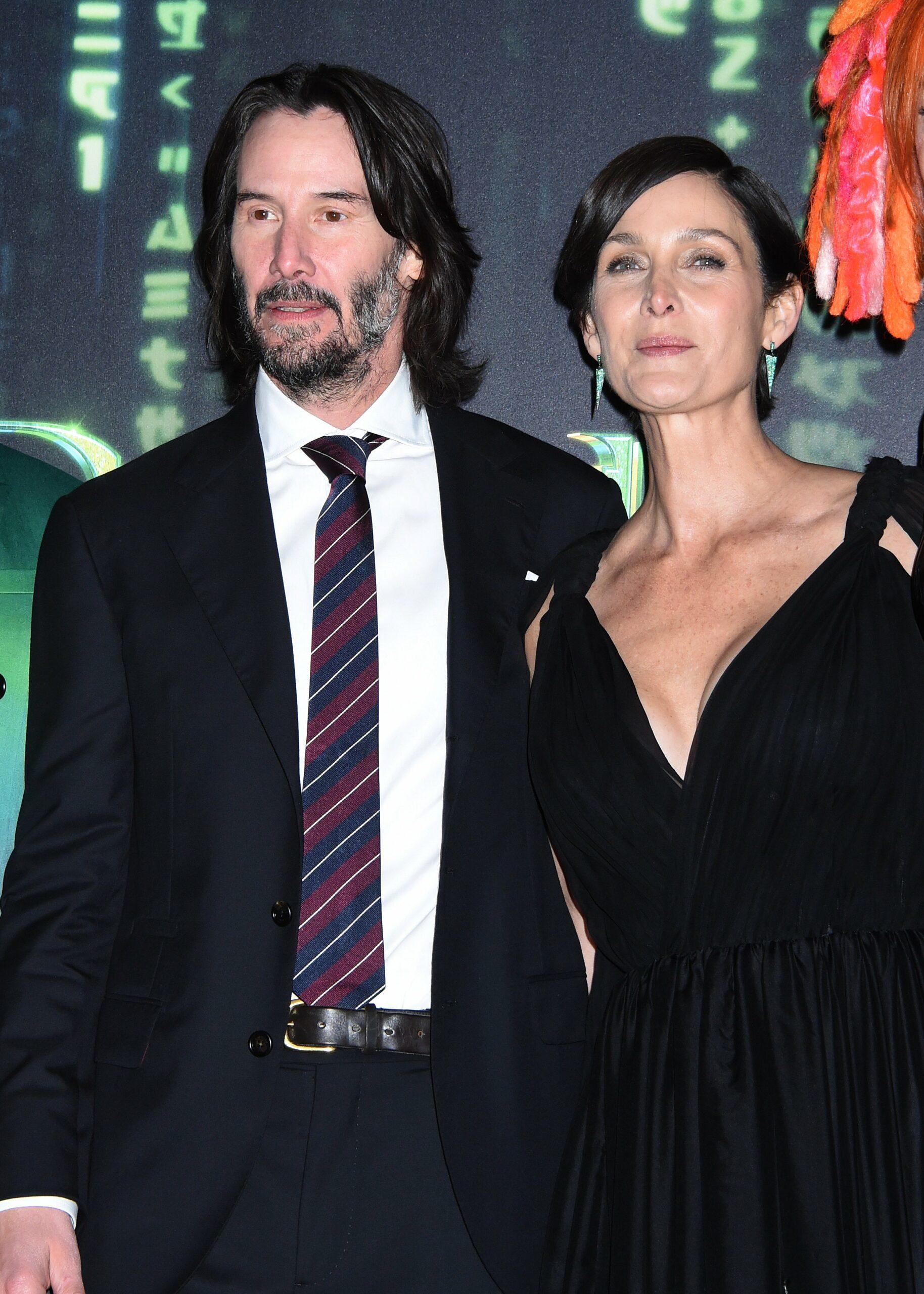 Keanu Reeves and Carrie-Anne Moss posing for the camera.