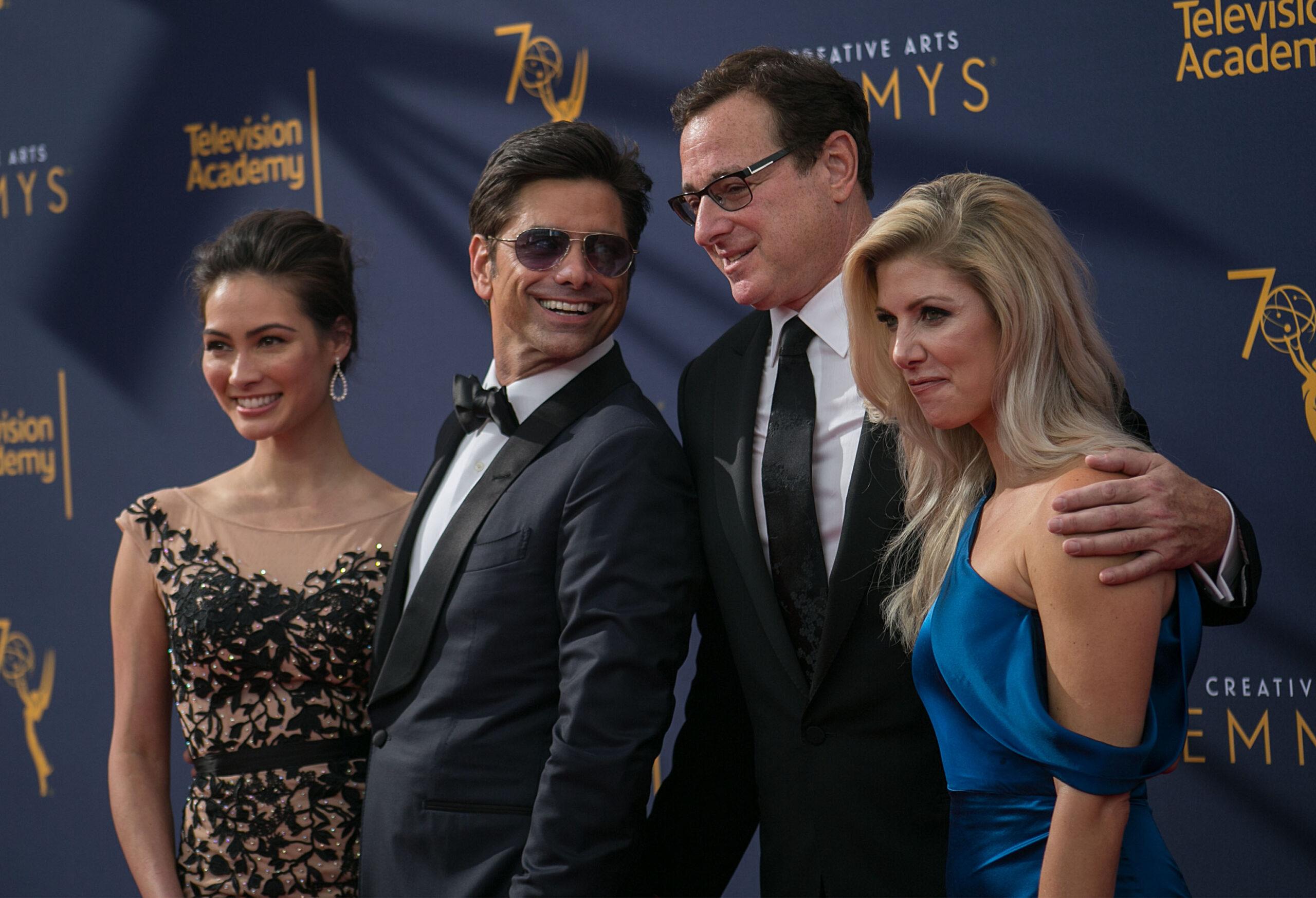 Caitlin McHugh, John Stamos, Bob Saget, and Kelly Rizzo smiling.