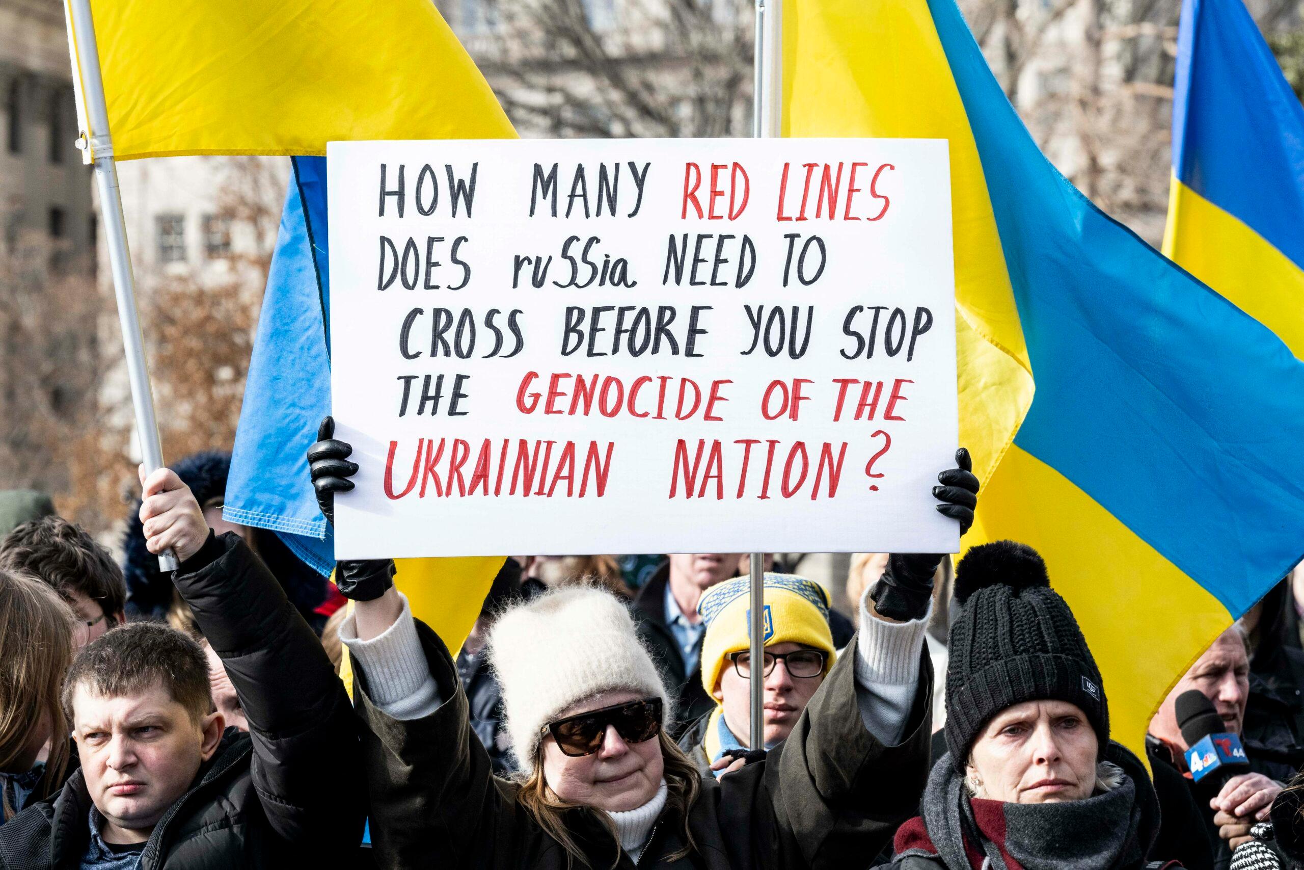 Washington, DC, United States: Ukrainian flags at a rally in front of the White House in support of Ukraine. 13 Mar 2022 Pictured: Washington, DC, United States: Woman holding a sign saying ''How many red lines does Russia need to cross before you stop the genocide of the Ukrainian nation?'' at a rally in front of the White House in support of Ukraine. Photo credit: ZUMAPRESS.com / MEGA TheMegaAgency.com +1 888 505 6342 (Mega Agency TagID: MEGA837908_003.jpg) [Photo via Mega Agency]