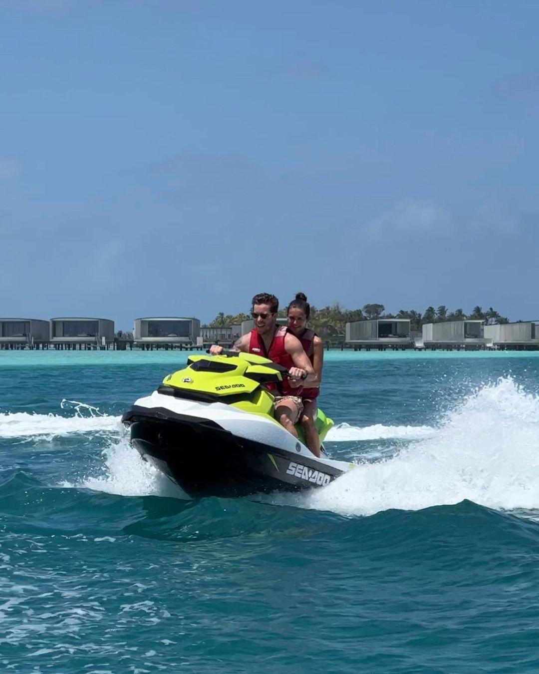 Shaun White and Nina Dobrev riding a jet ski.