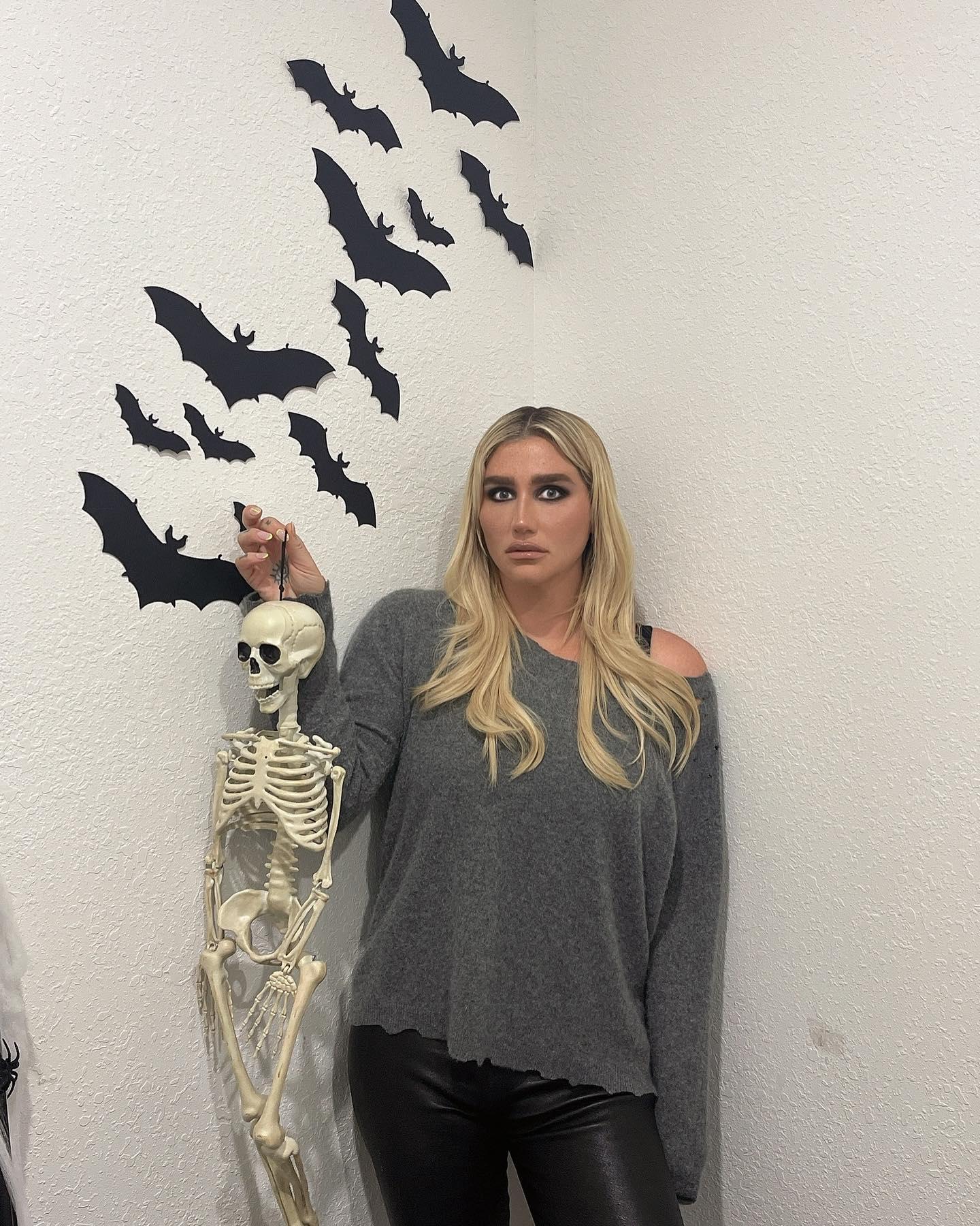 Kesha holds up a skeleton