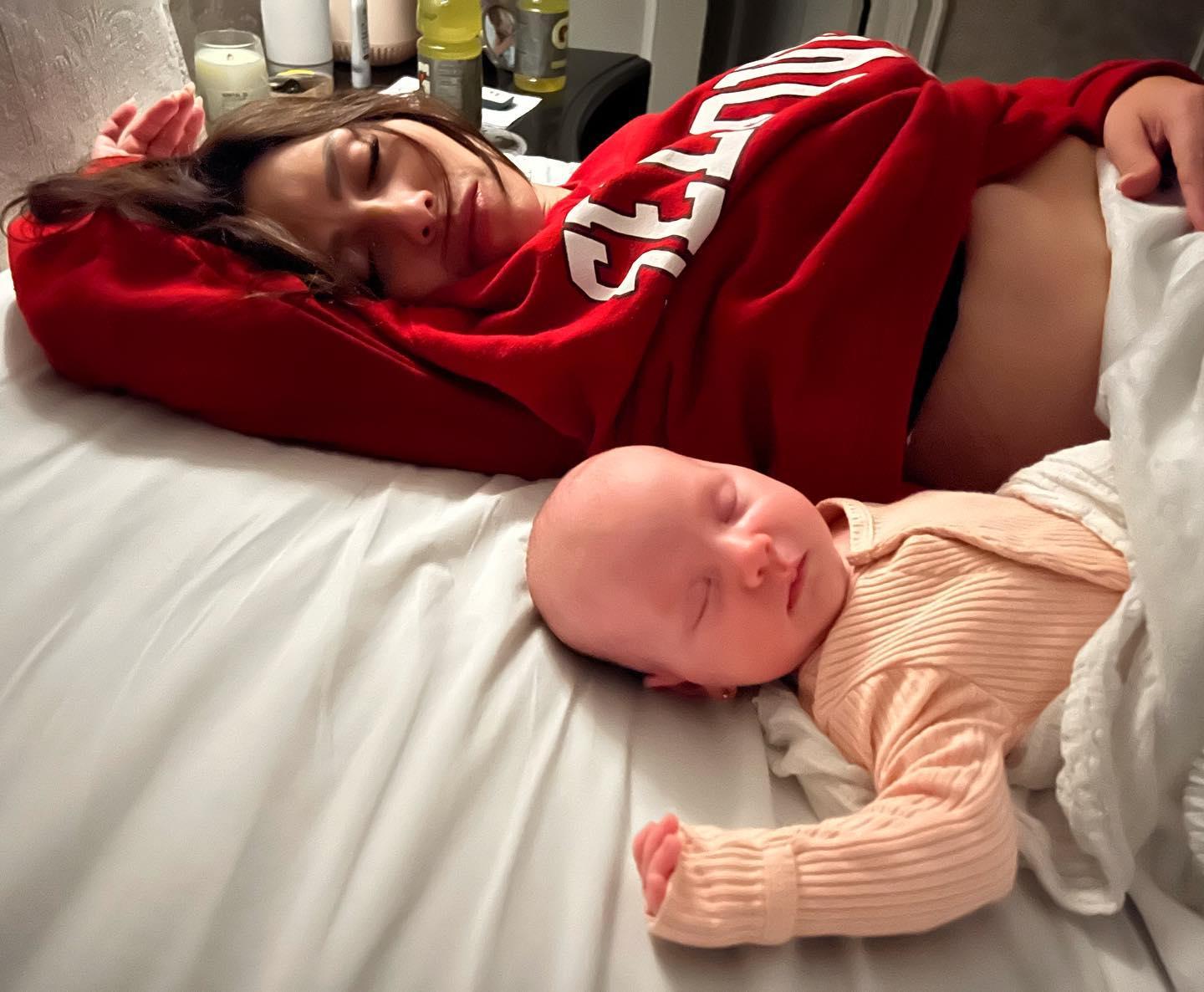 Hilaria sleeping with her newborn daughter