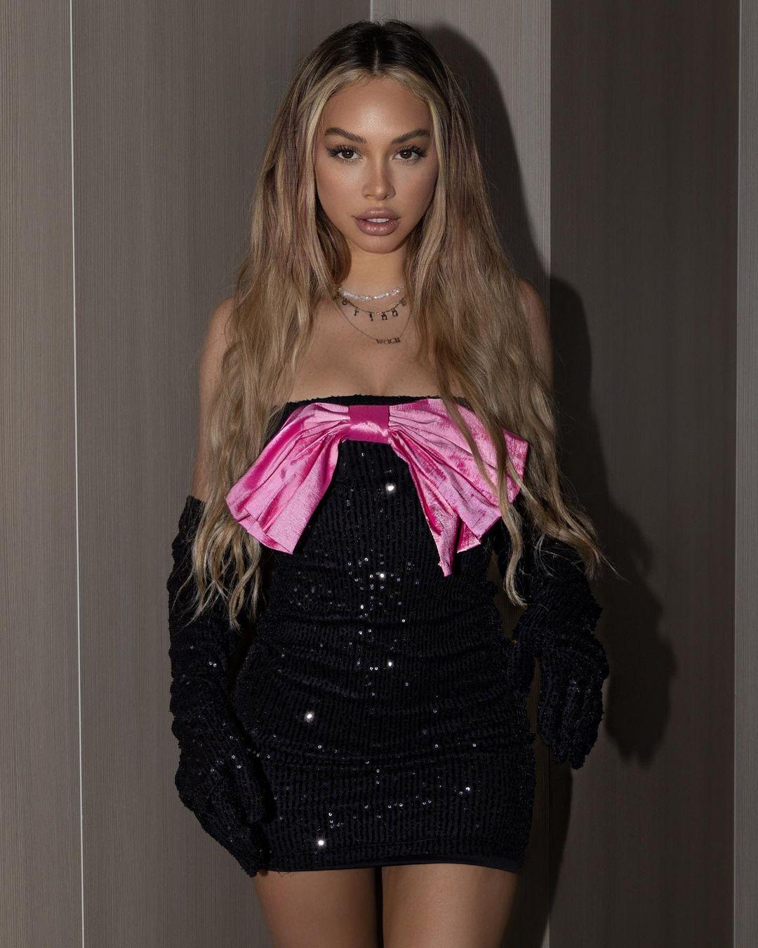 Corinne Olympios wears black and pink holiday dress