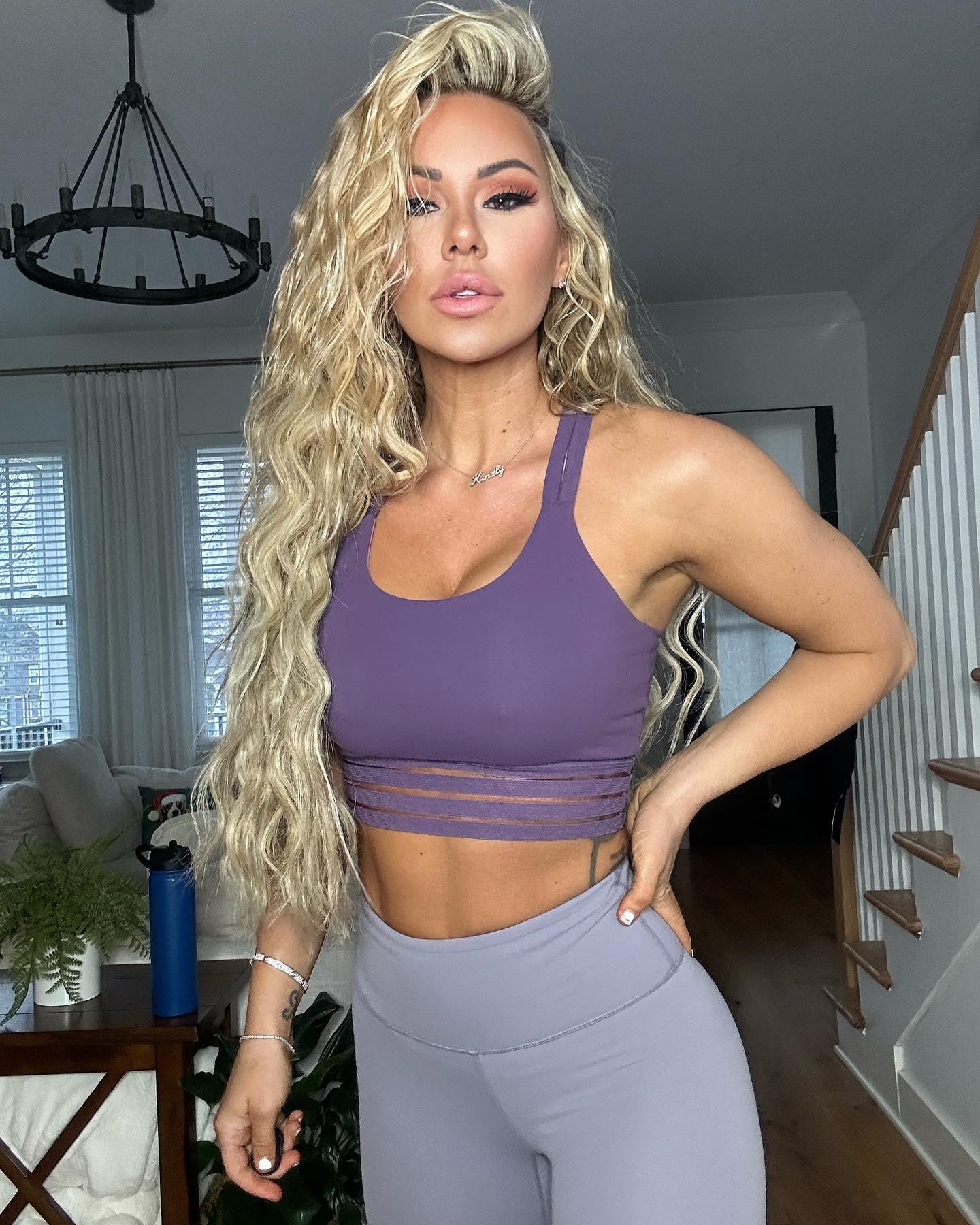 Kindly Myers shows off her new hair and a new outfit: a purple sports bra and gray CNC leggings