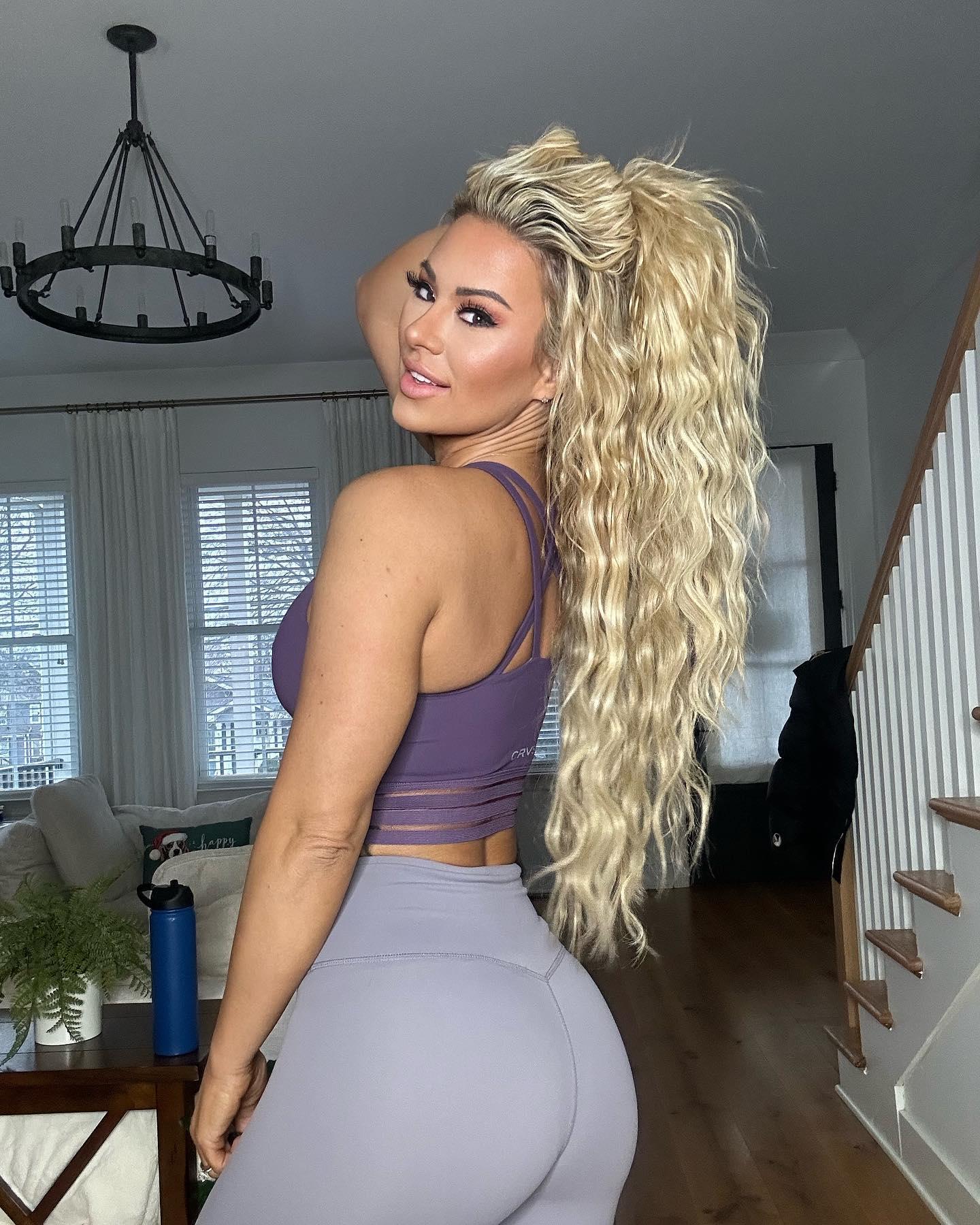 Kindly Myers shows off her new hair and a new outfit: a purple sports bra and gray CNC leggings