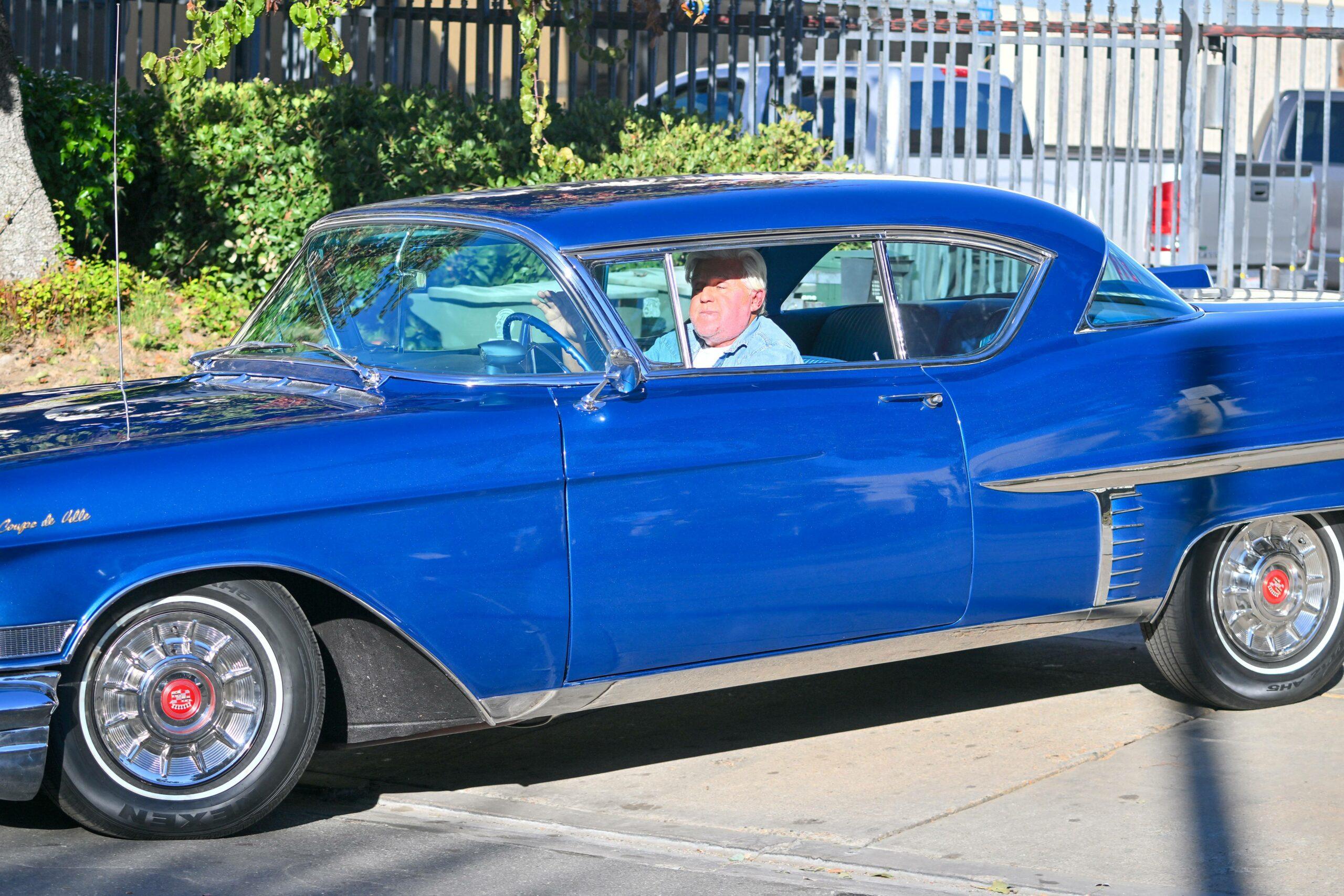 Jay Leno stops by a gas station in yet another cool car after getting out of the hospital yesterday