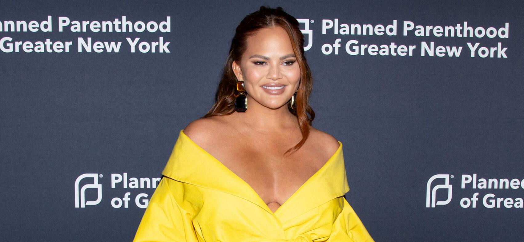 Chrissy Teigen dons plunging black swimsuit for hike with husband