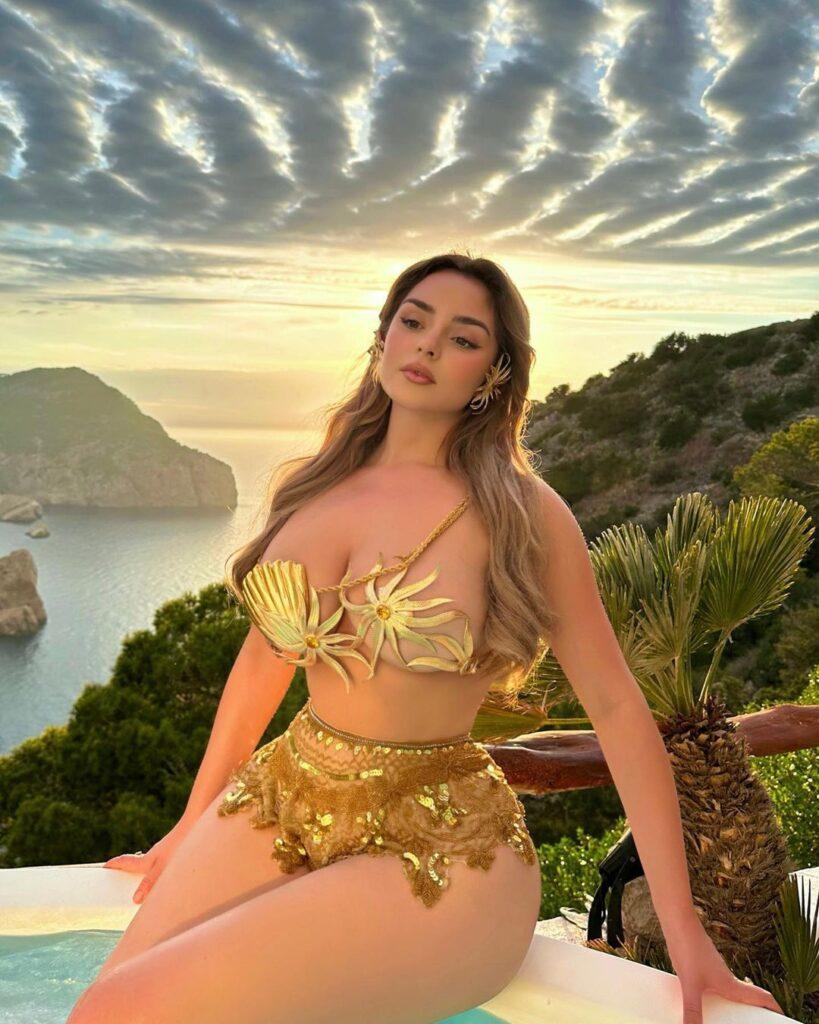 Demi Rose sitting on the edge of the pool.