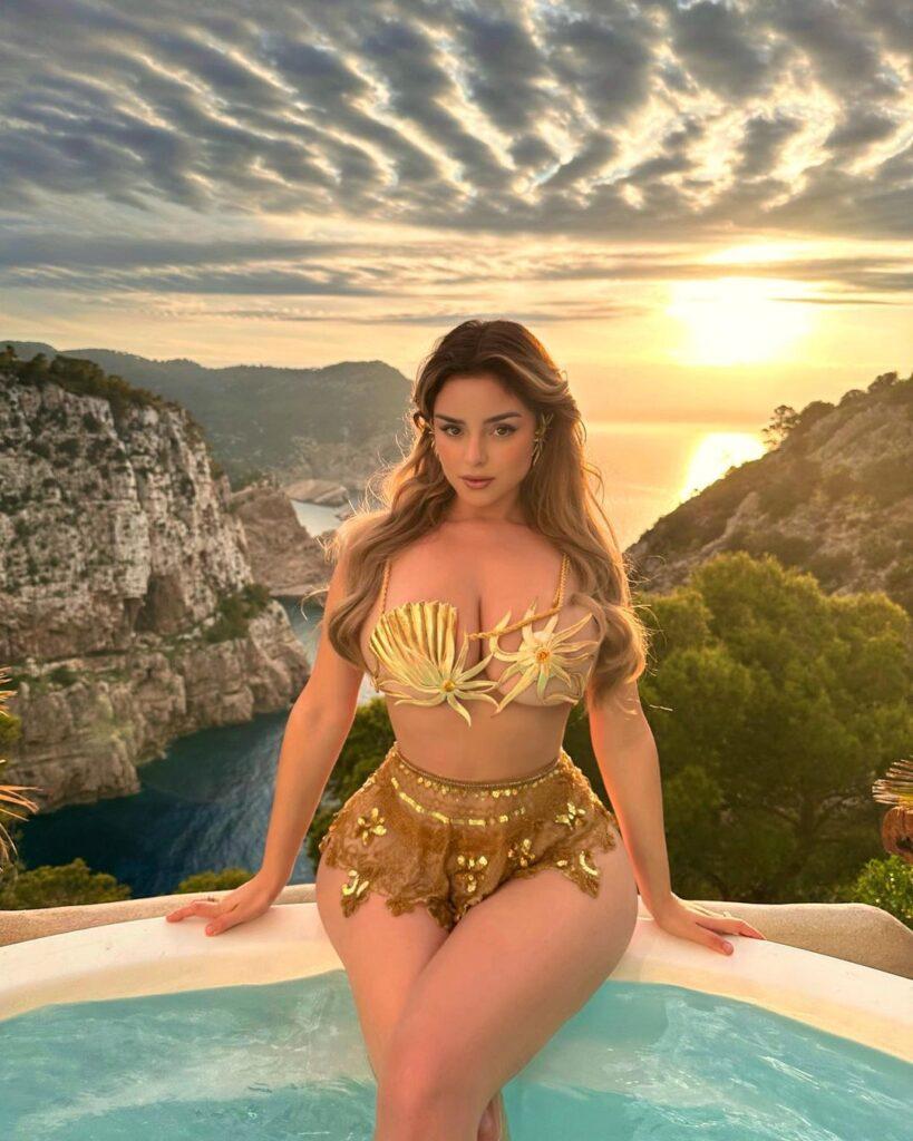 Demi Rose sitting on the edge of the pool.