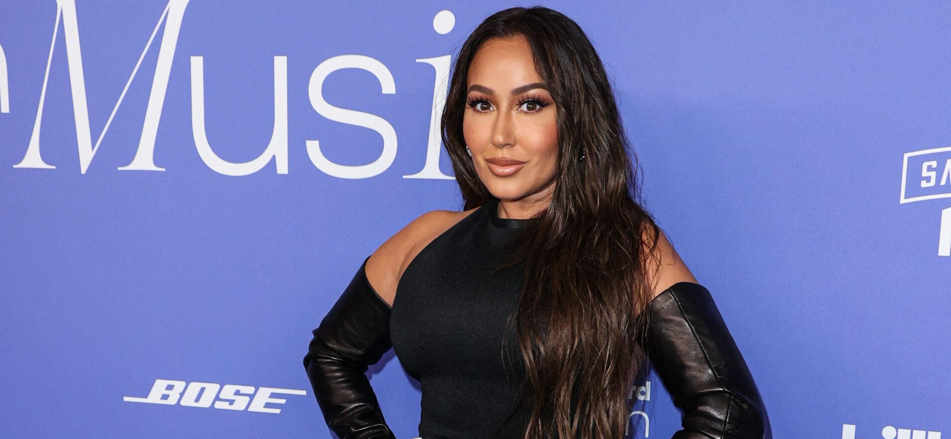 Adrienne Bailon Is Serving ‘Curves & Cellulite’ In Black Swimsuit During Family Vacation In Ibiza