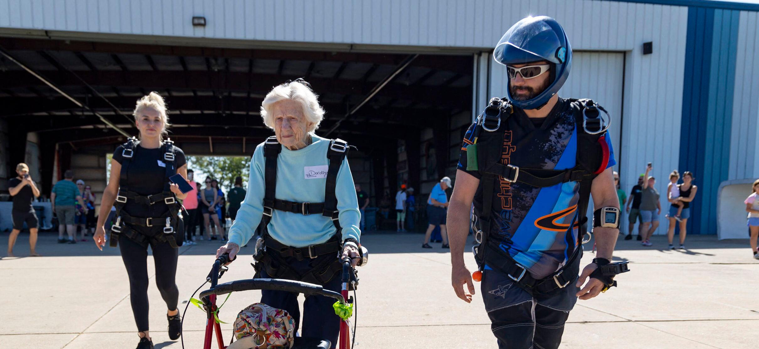 Skydiver Dorothy Hoffner, 104, pushes her walker out to the plane with tandem jumper Derek Baxter