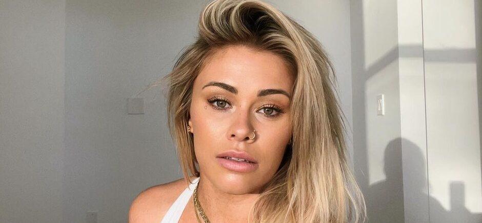 Paige VanZant takes a a selfie in a low-cut white top.