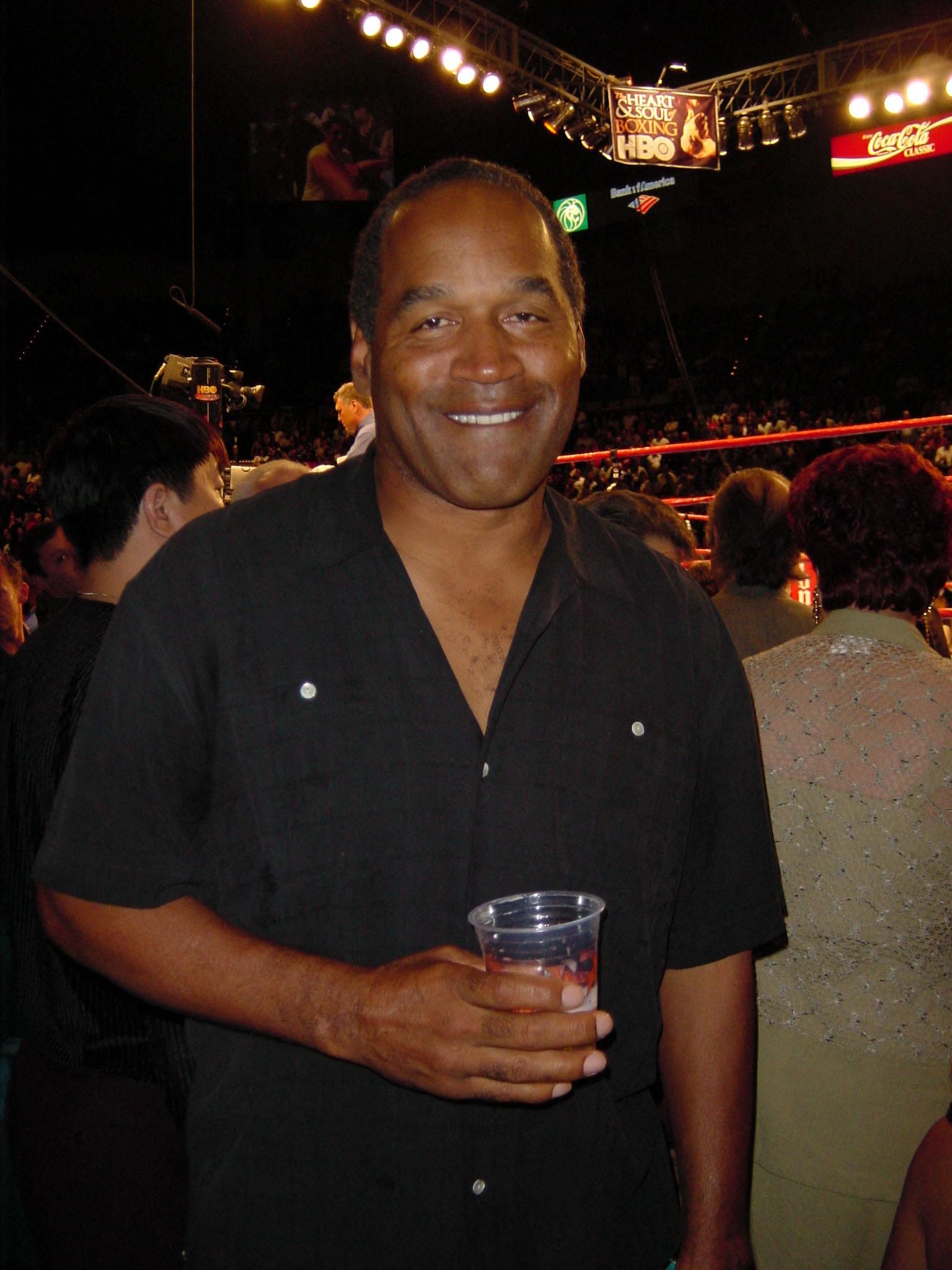 O.J. Simpson smiling while holding a drink