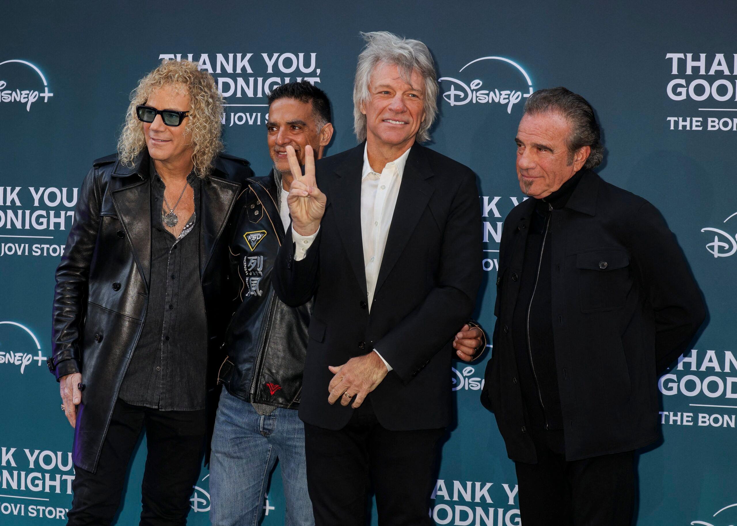 The band Bon Jovi poses on a red carpet.