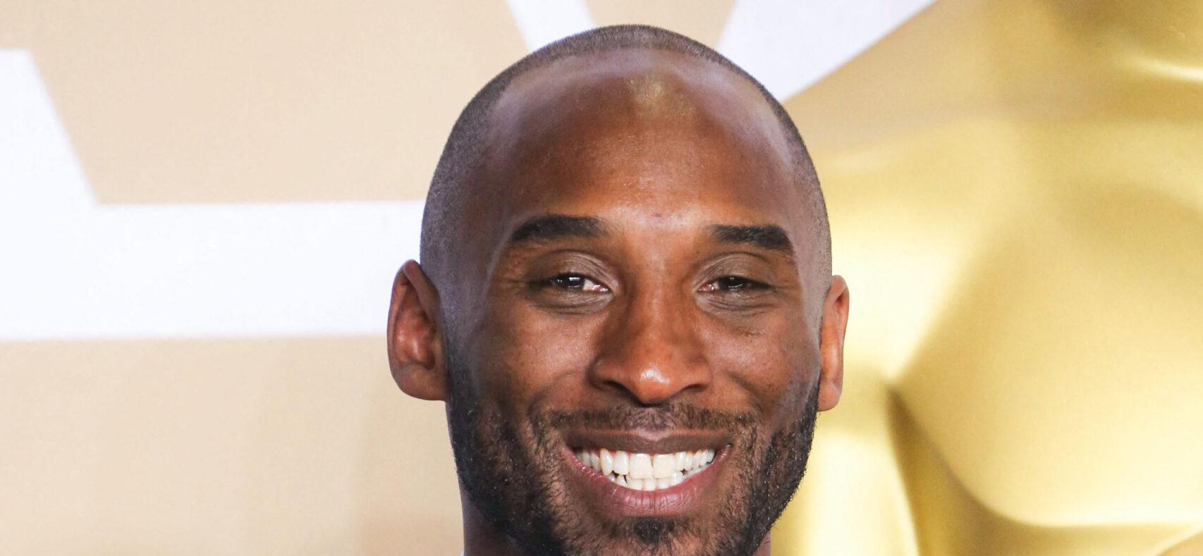 Kobe Bryant holding trophy in a tux