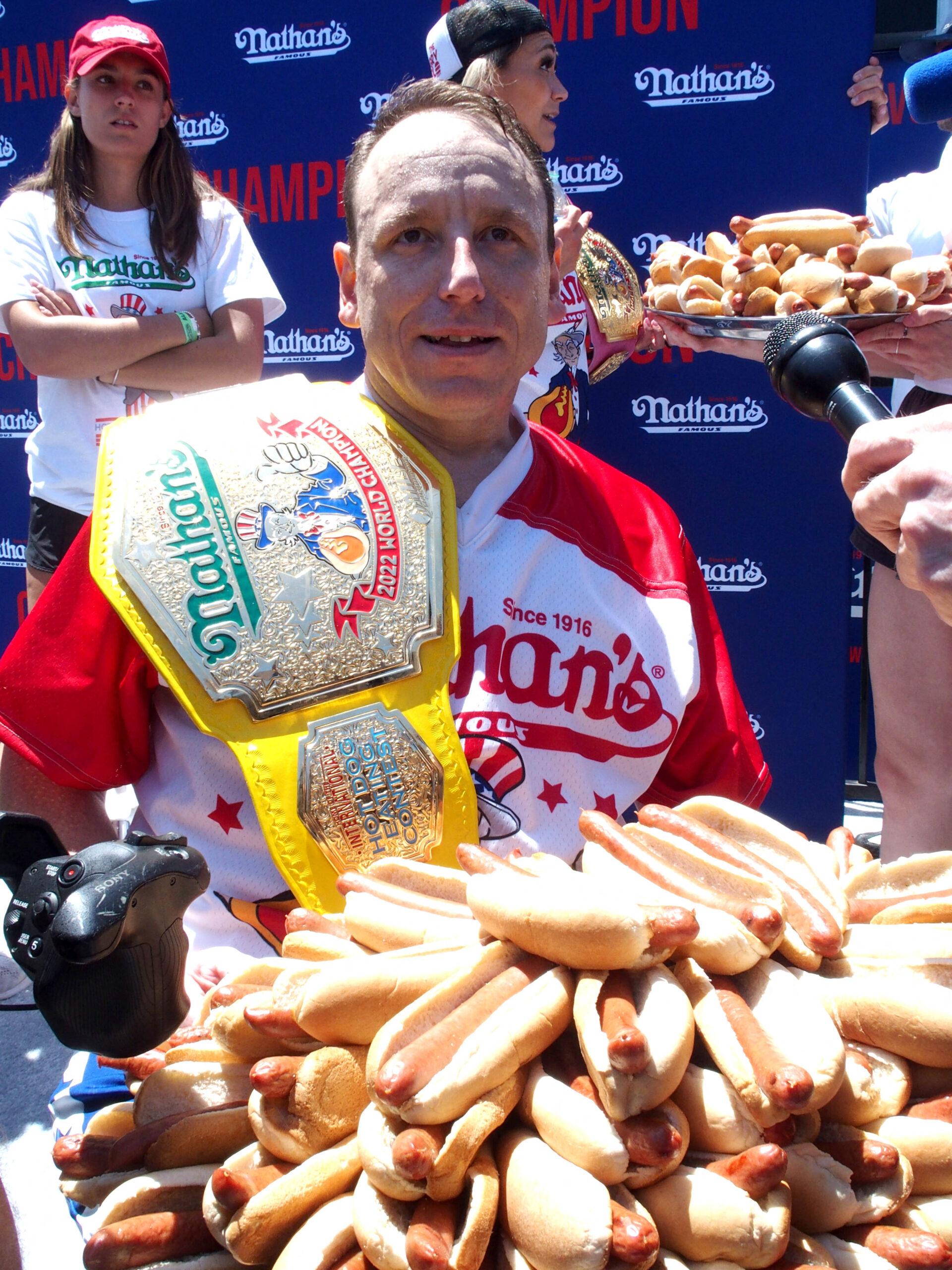 Joey Chestnut holding a plate of hot dogs