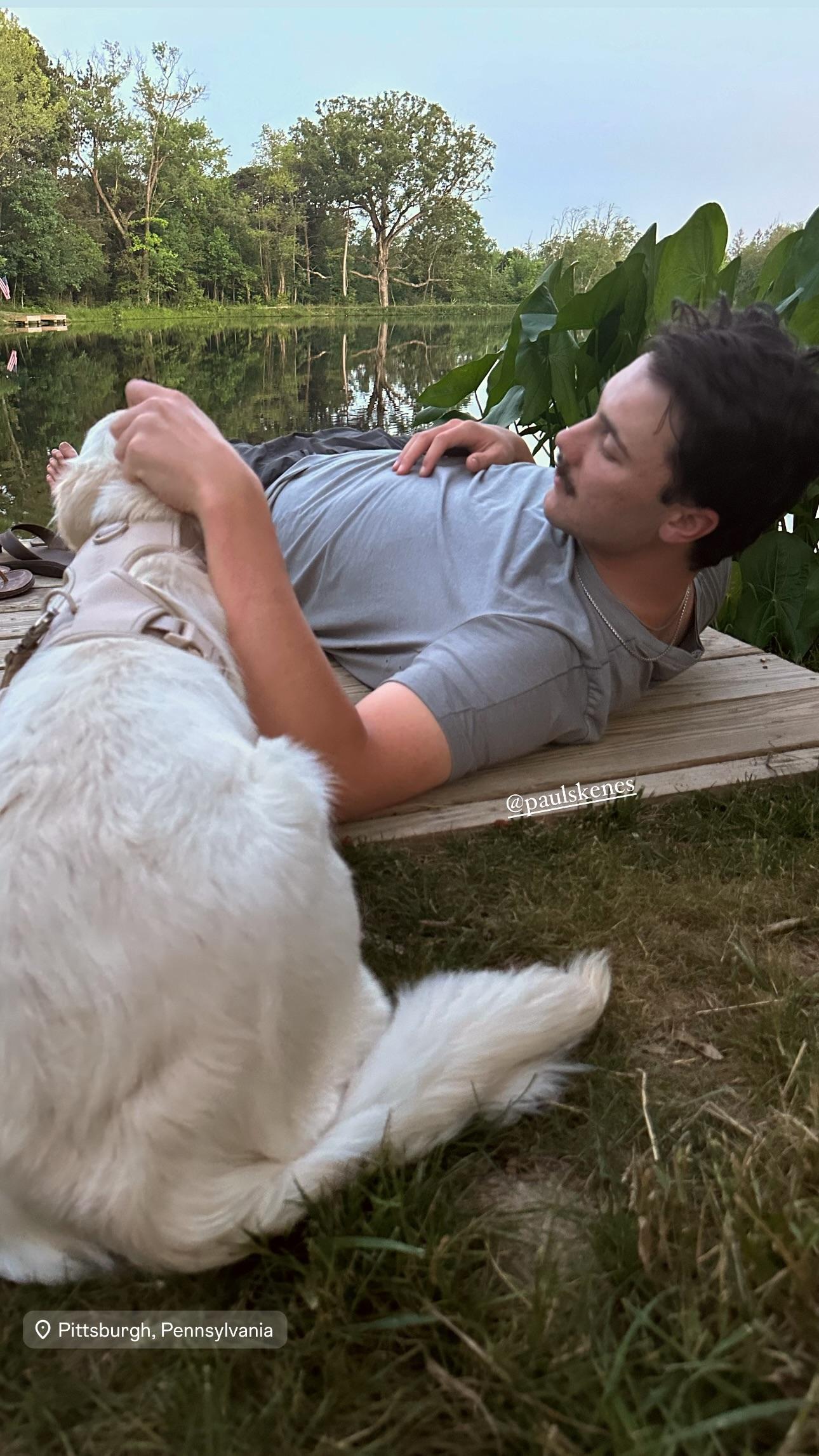 Paul Skenes lounging on a wooden deck with his dog.