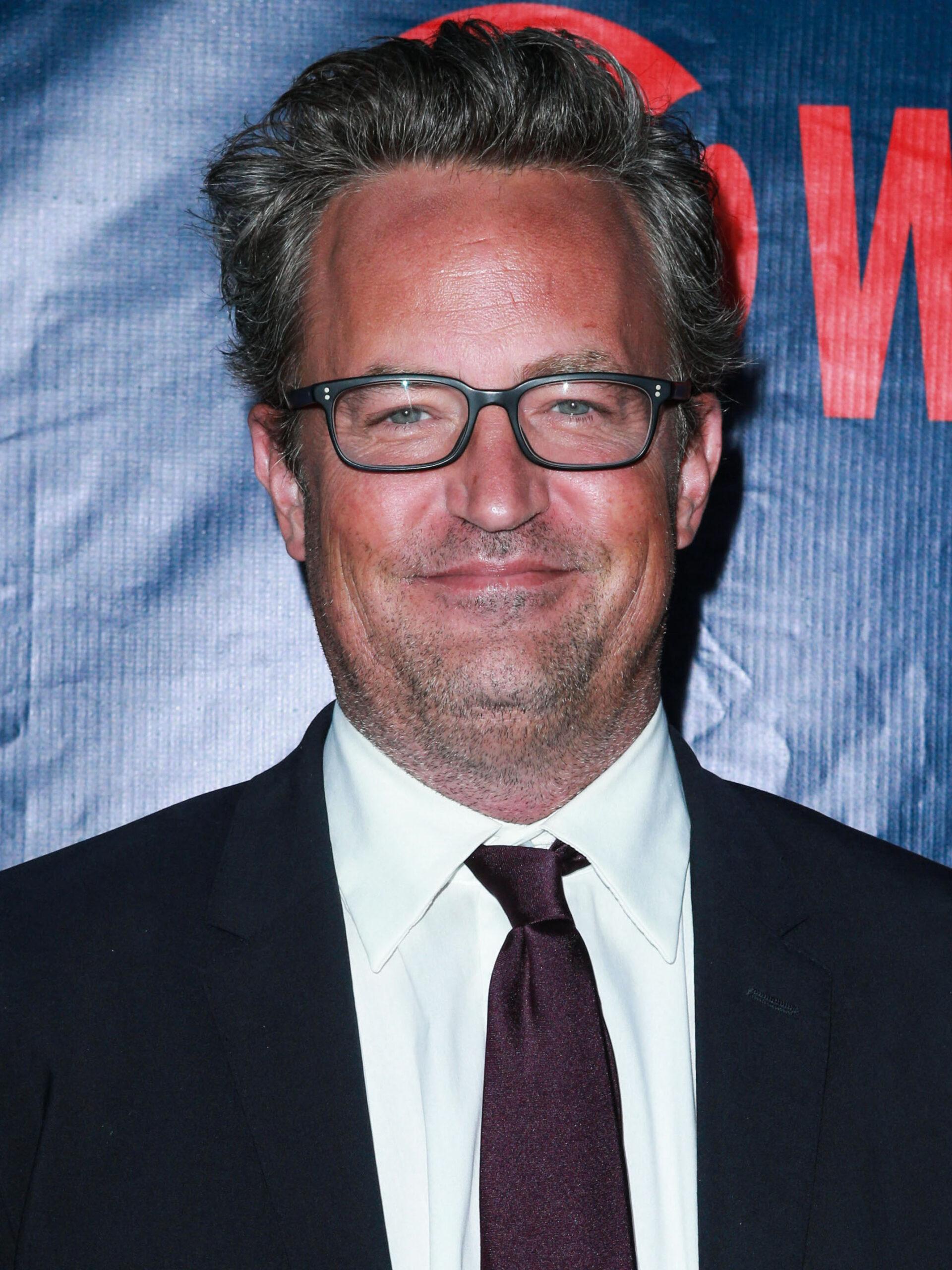 Matthew Perry wearing glasses and smiling at Netflix premiere