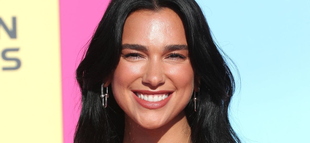 Dua Lipa smiles at an event