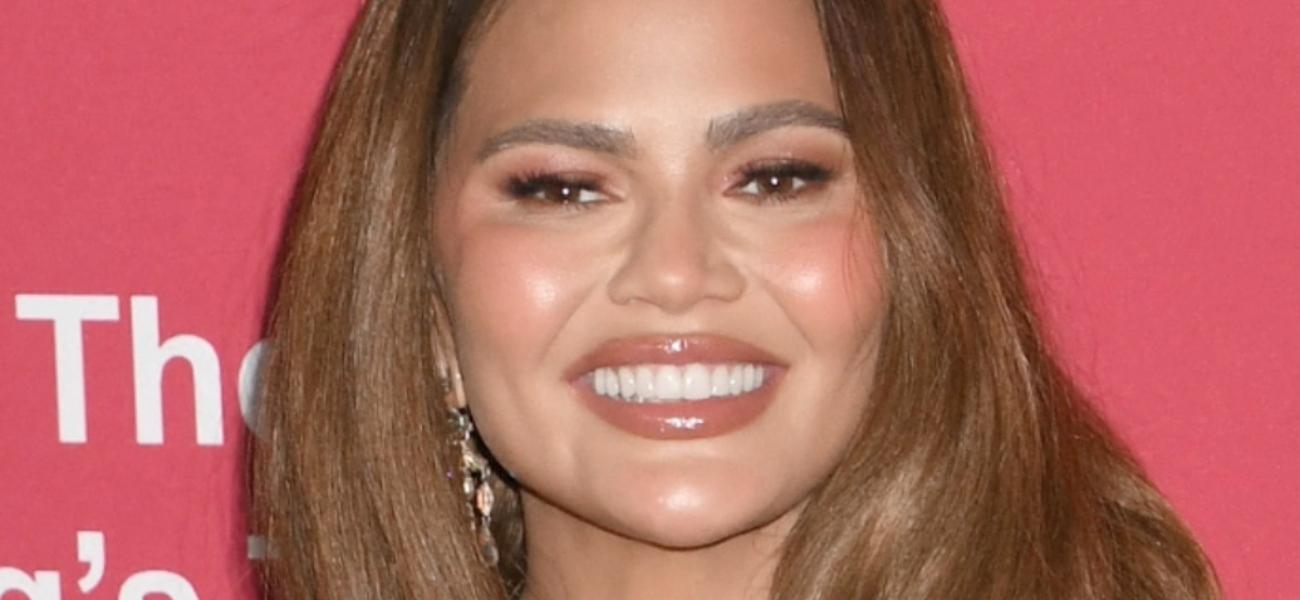 Chrissy Teigen smiles at an event