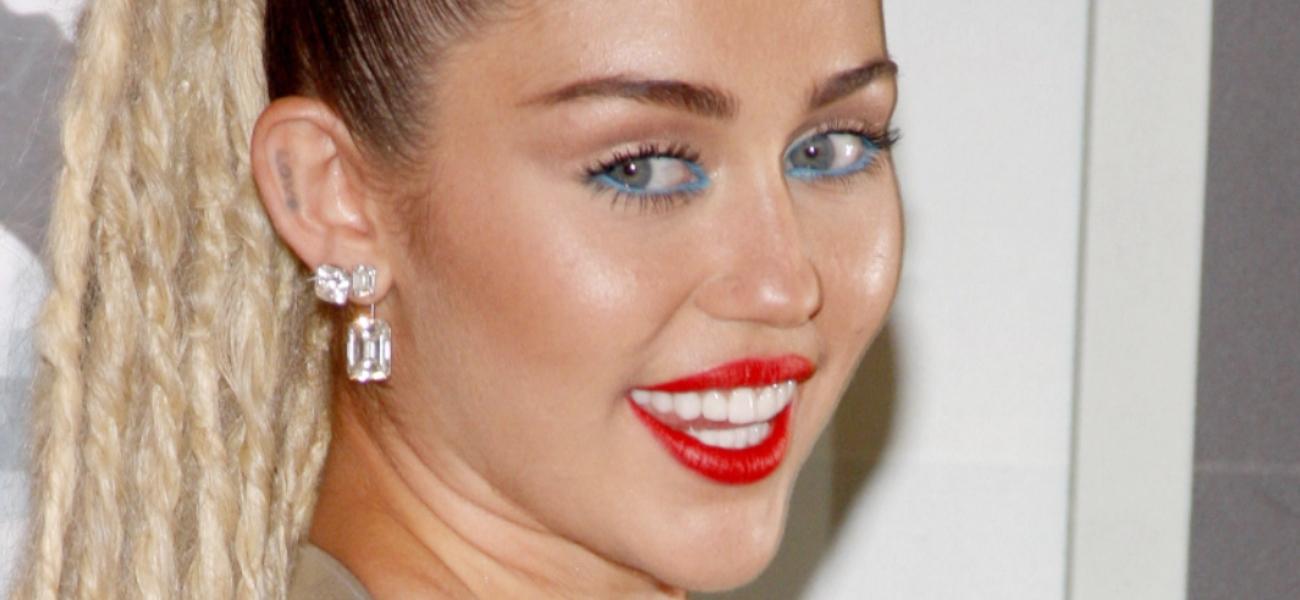 Miley Cyrus poses with red lipstick