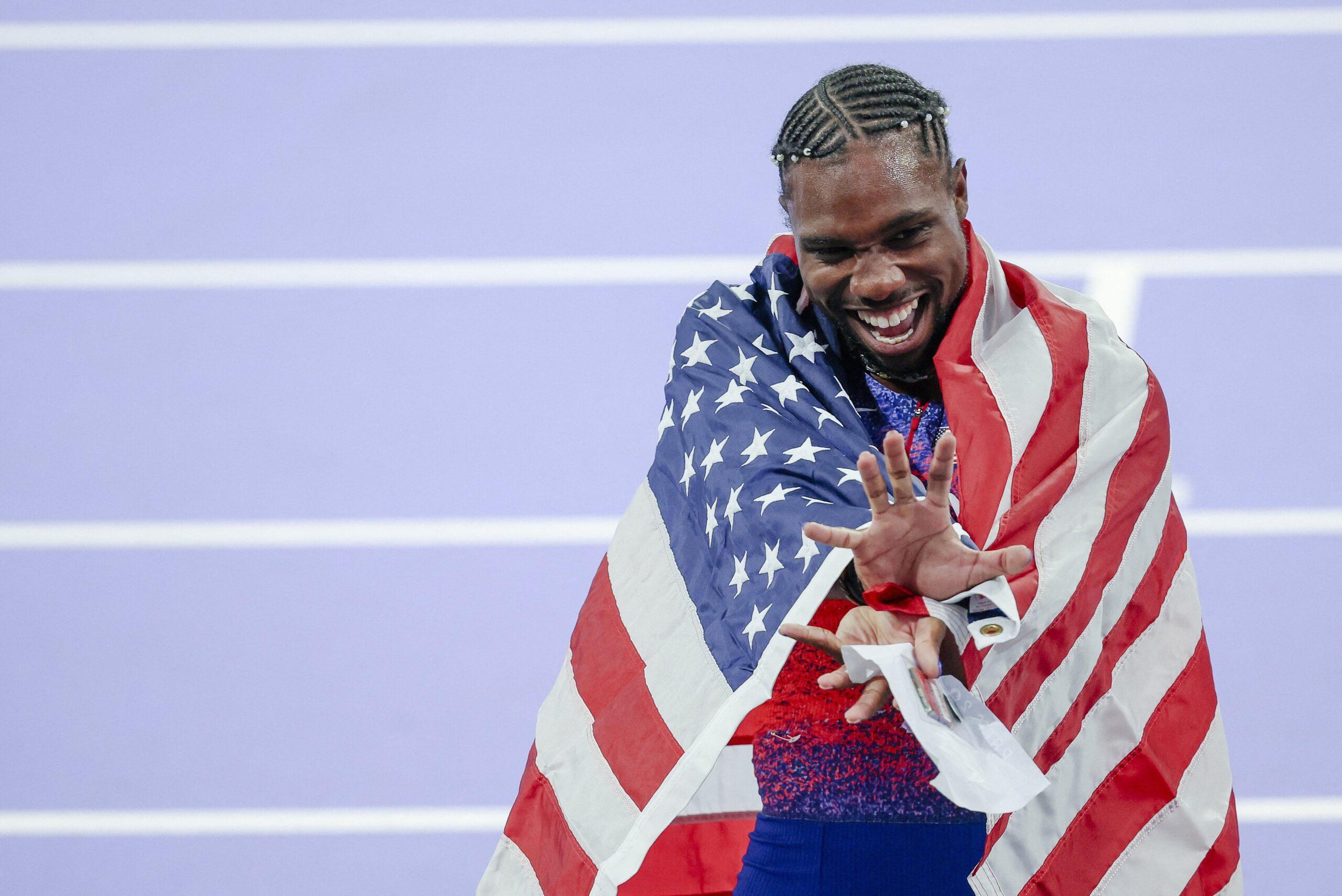 Noah Lyles celebrating at the 2024 Paris Olympics with American Flag