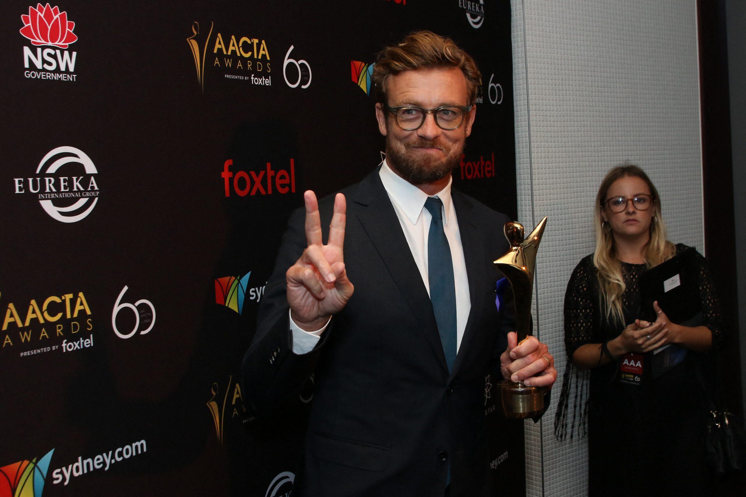 Simon Baker attends the 8th AACTA award winners pose with trophies in media room