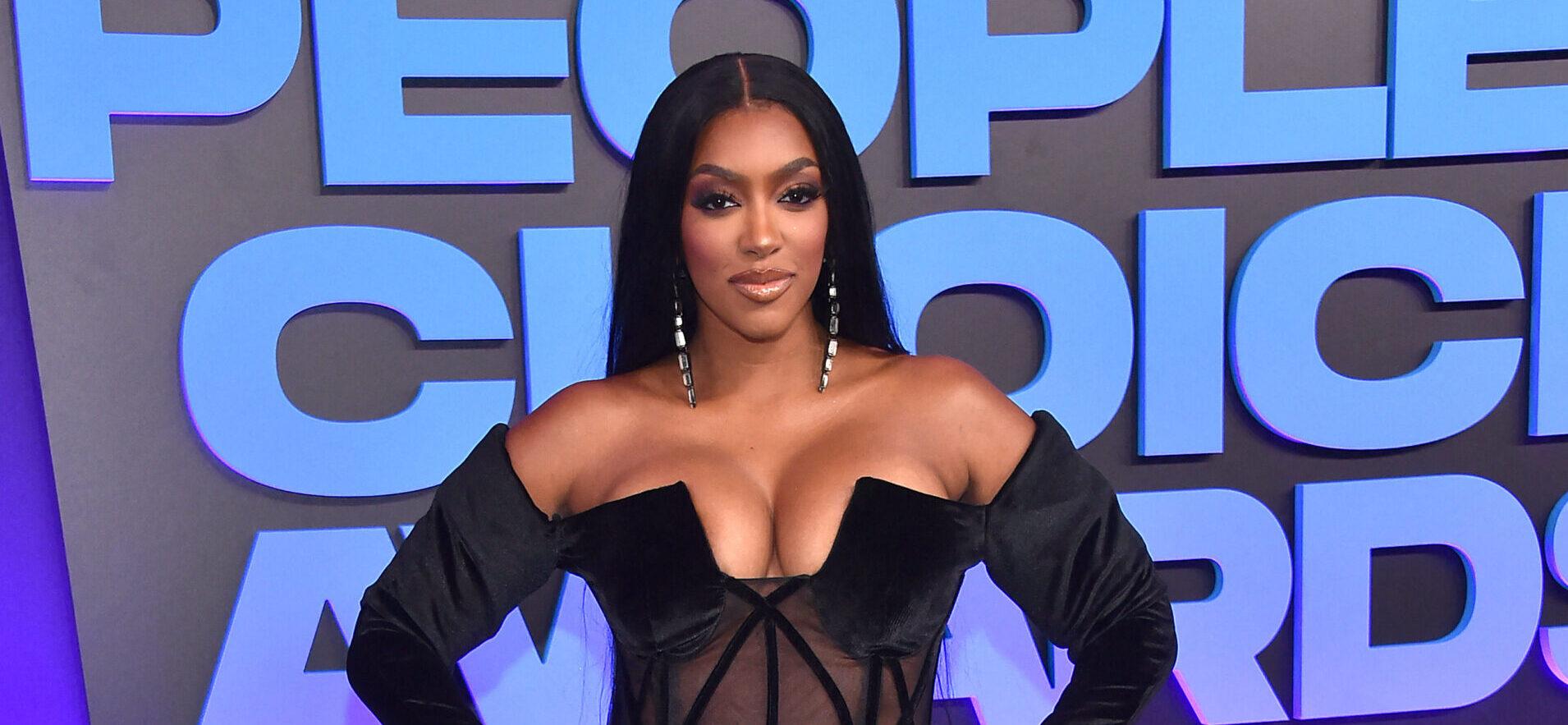 Porsha Williams posing in a black dress on the red carpet.