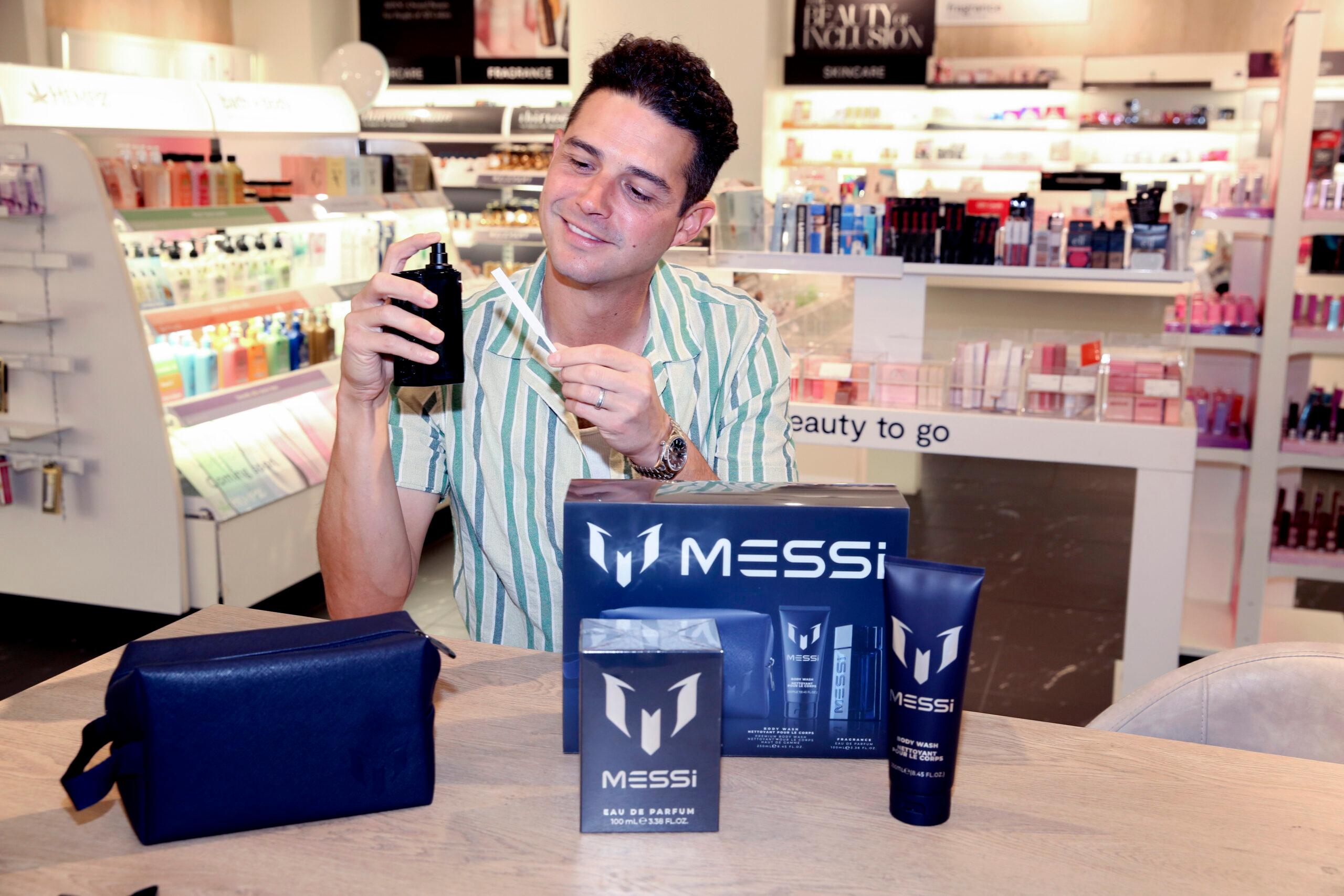 Wells Adams holding cologne in JCPenney