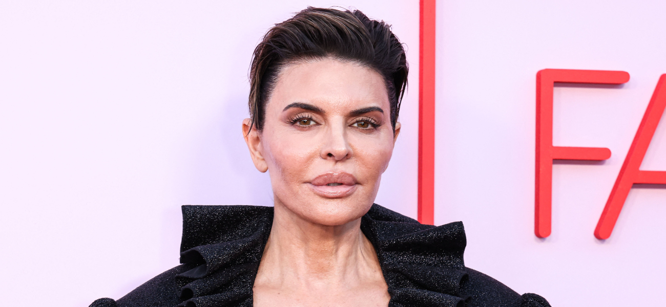 Lisa Rinna posing in a black outfit on the red carpet.