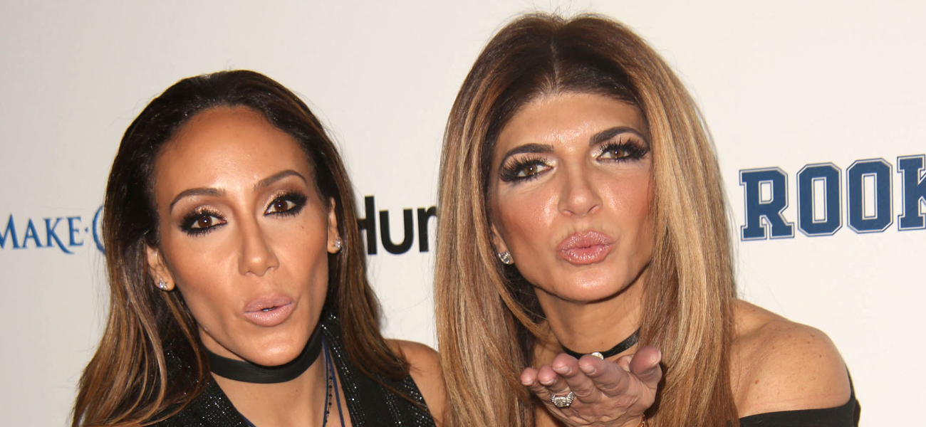 Teresa Giudice and Melissa Gorga posing next to each other and blowing kisses on the red carpet.