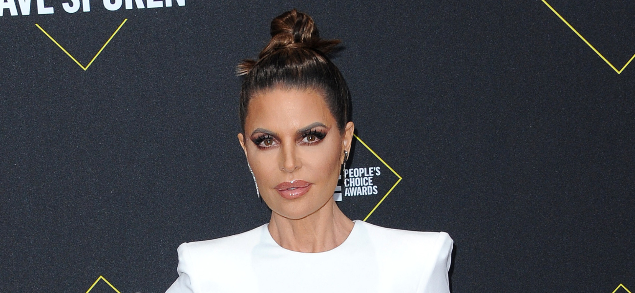 Lisa Rinna posing on the red carpet in a white dress.