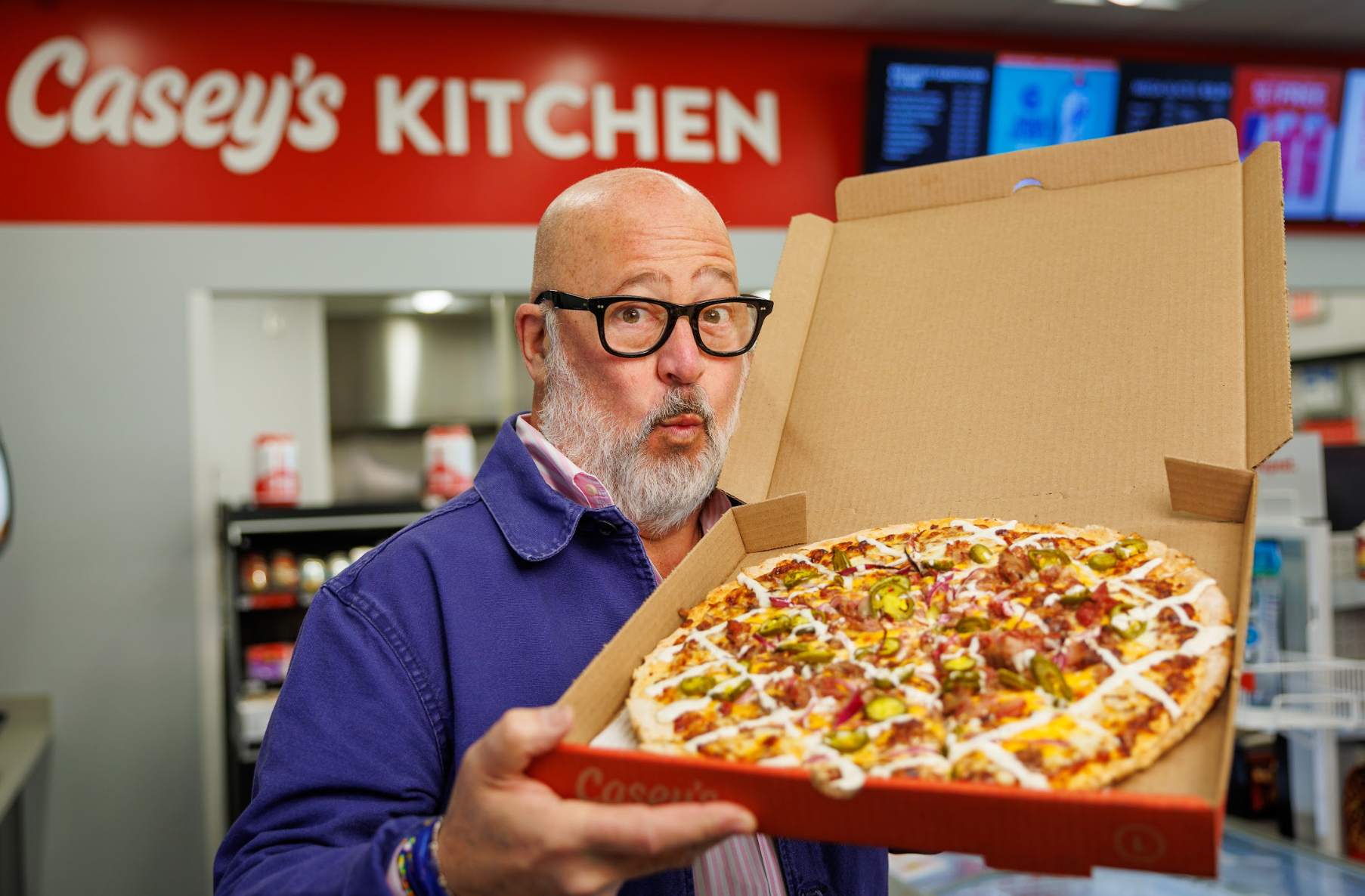 Andrew Zimmern holding Casey's pizza box