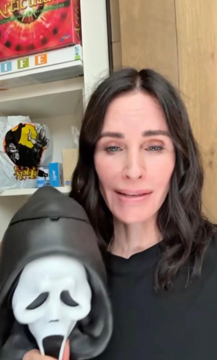Courteney Cox holding Scream mask
