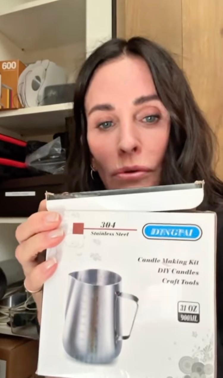 Courteney Cox holding a candle making kit
