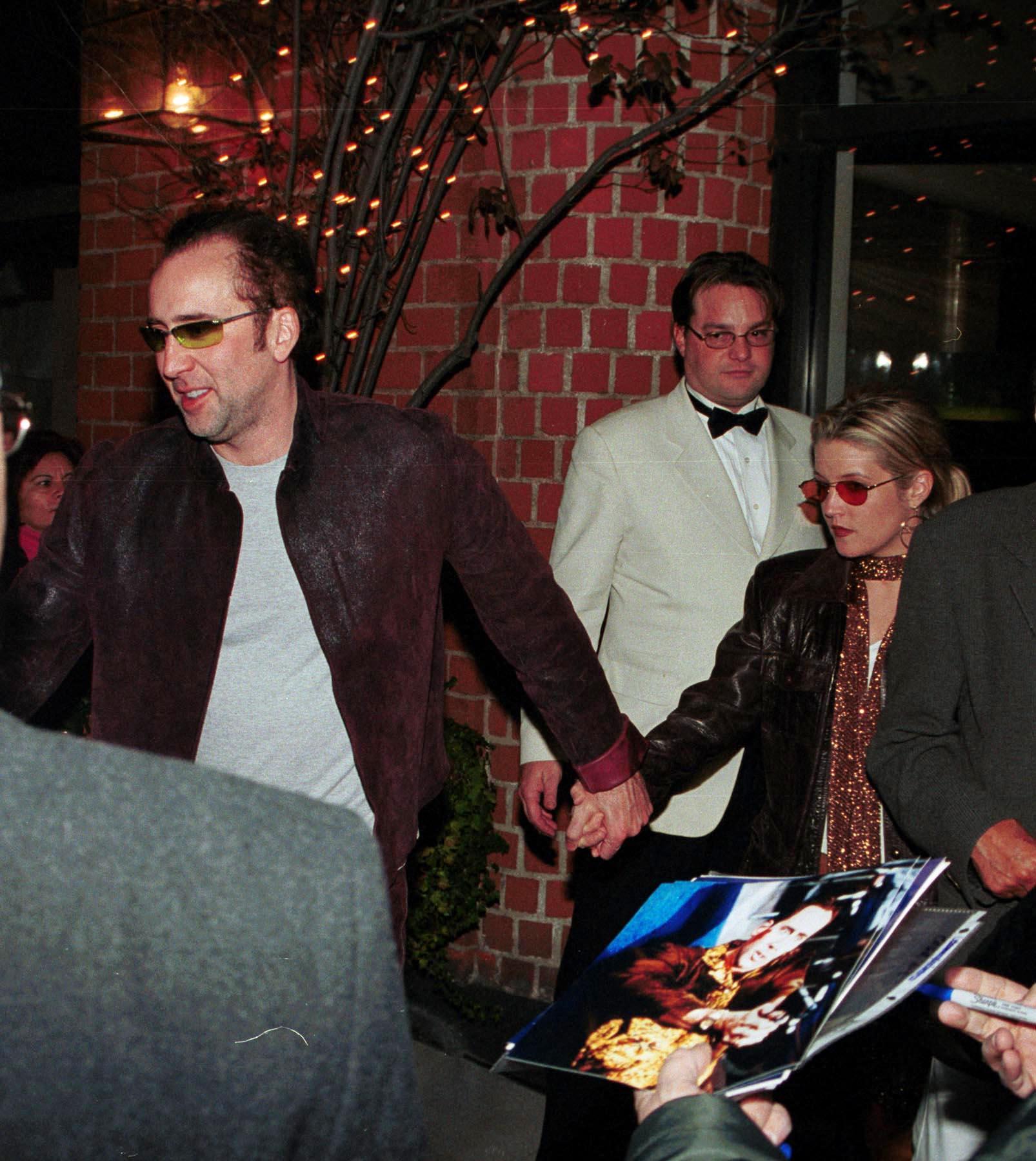 Lisa Marie Presley holding hands with Nicolas Cage