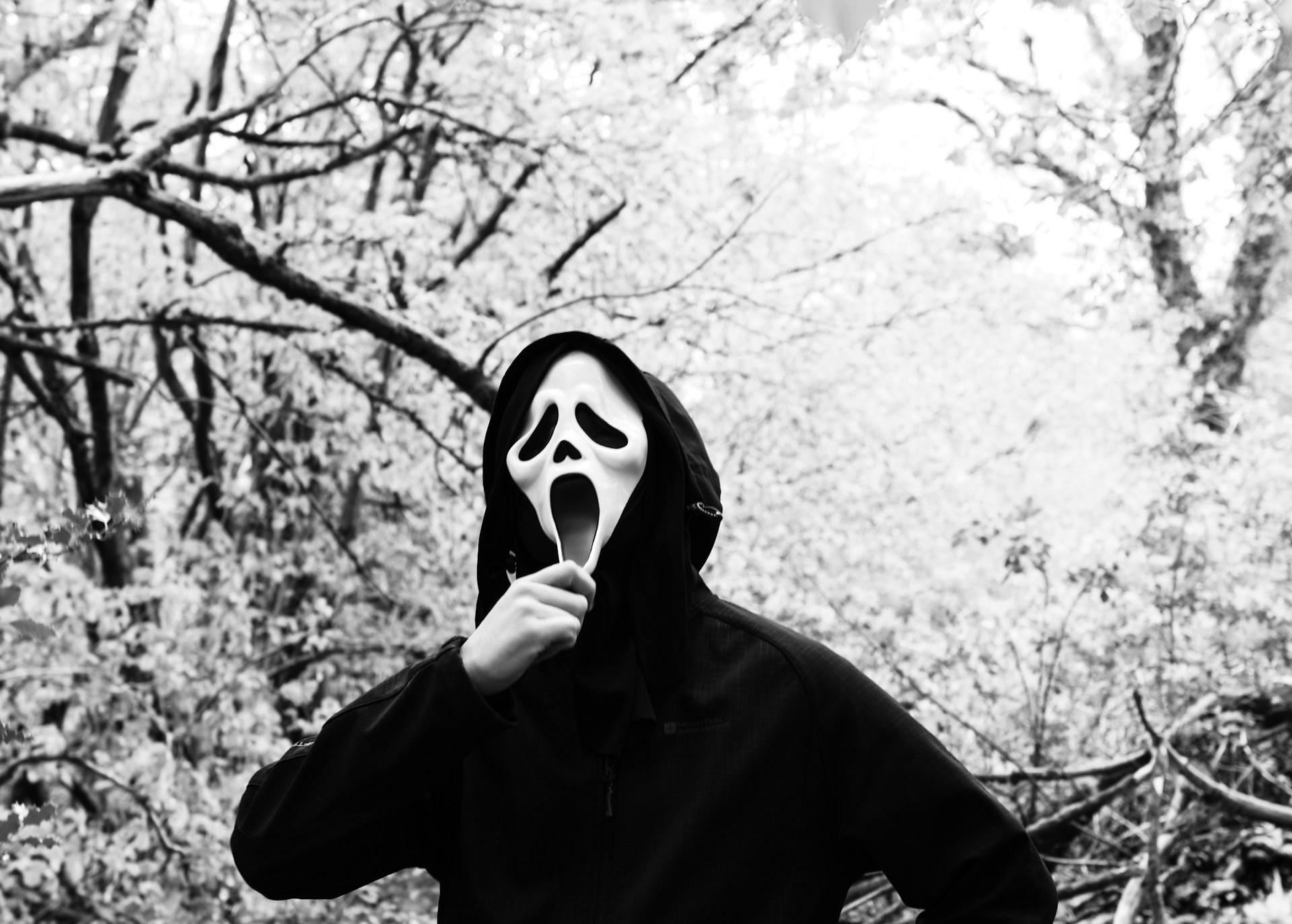 A man wearing a 'Scream' mask